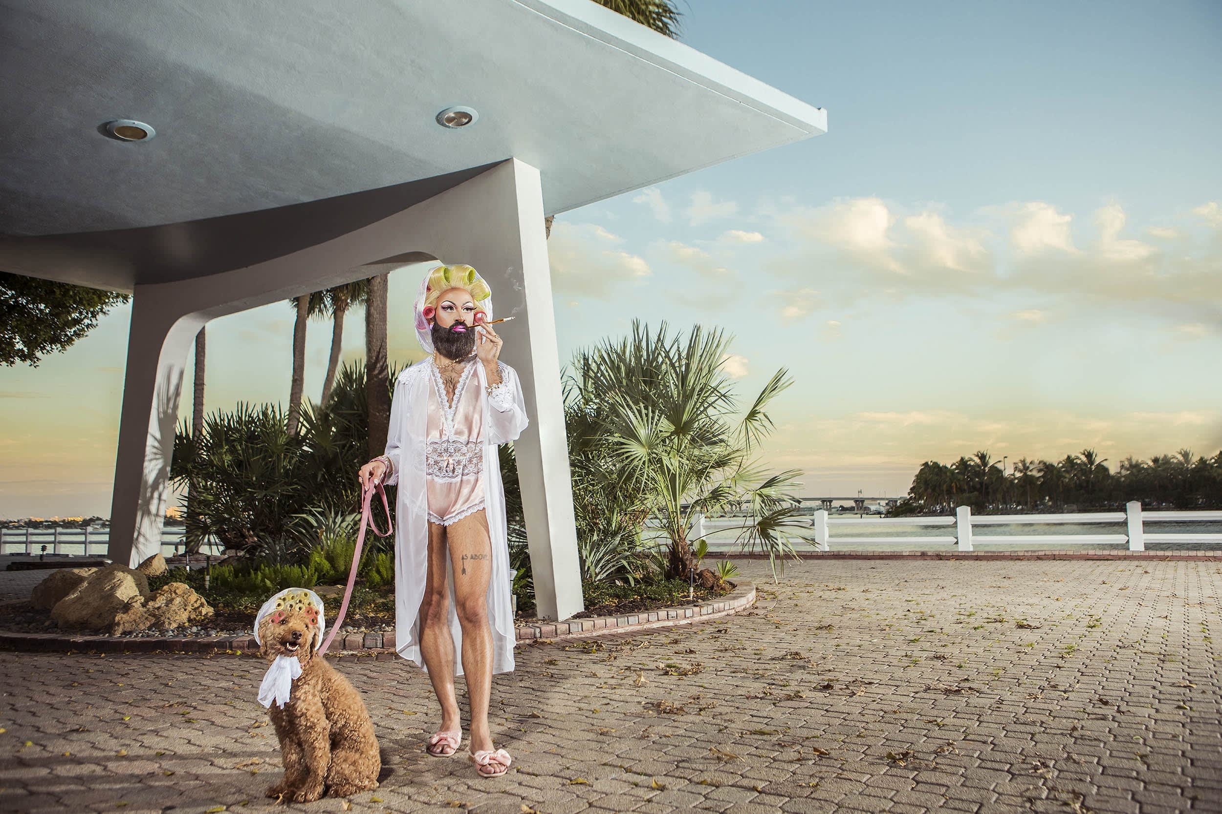 Photo of a man in drag lingerie walking a dog