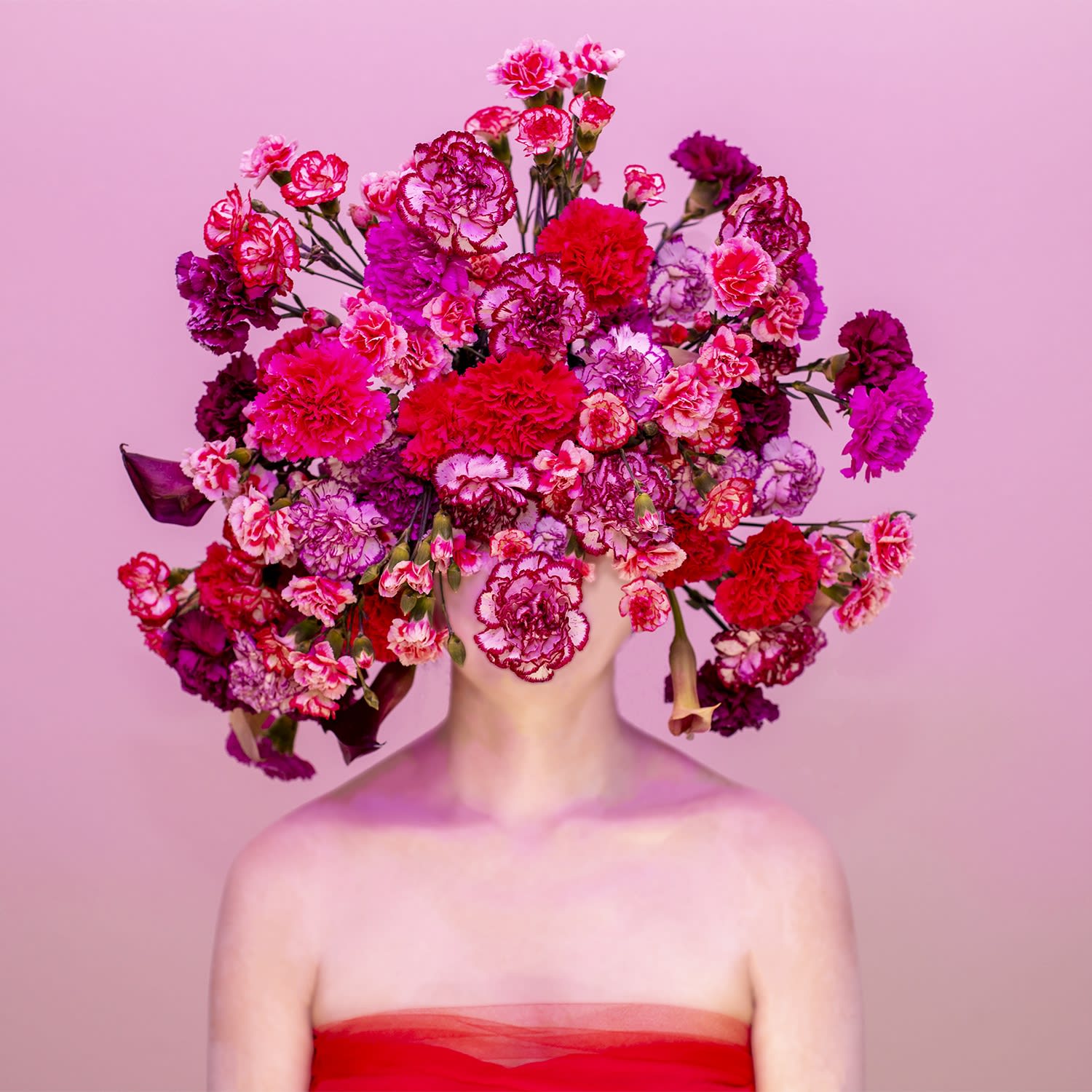 Photograph of woman in pink, face covered in pink and red flowers