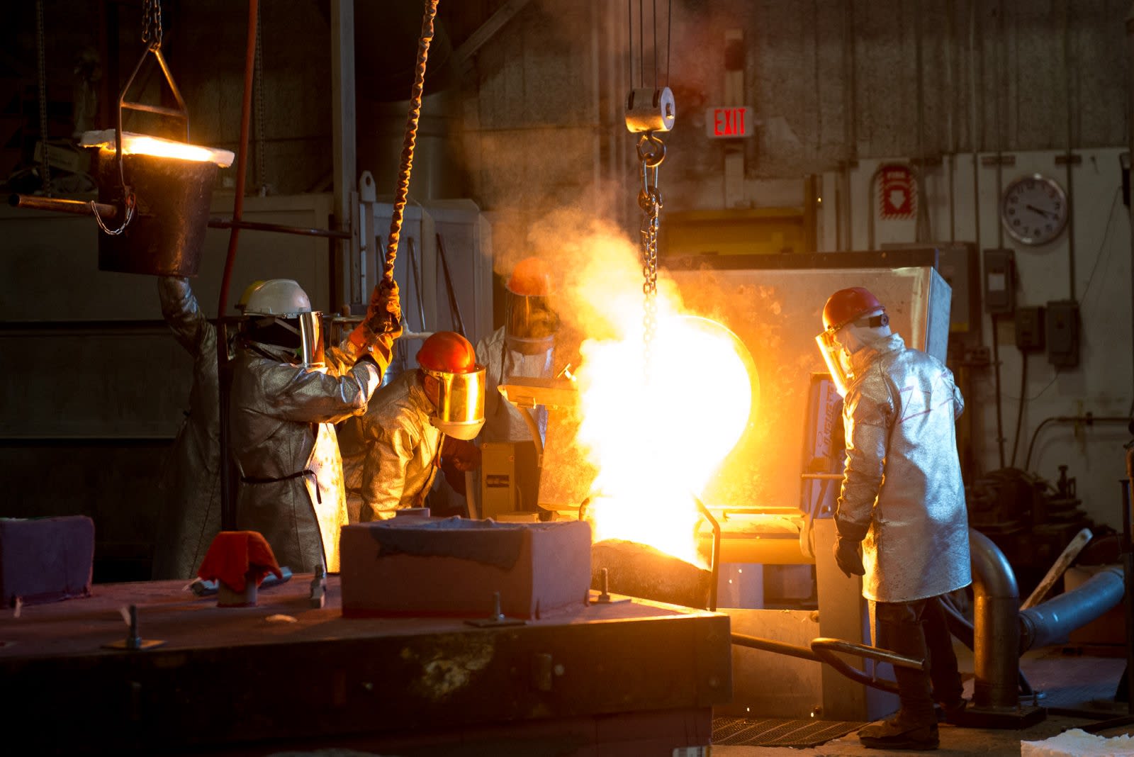 Workers pouring metal into a mold in a foundry.
