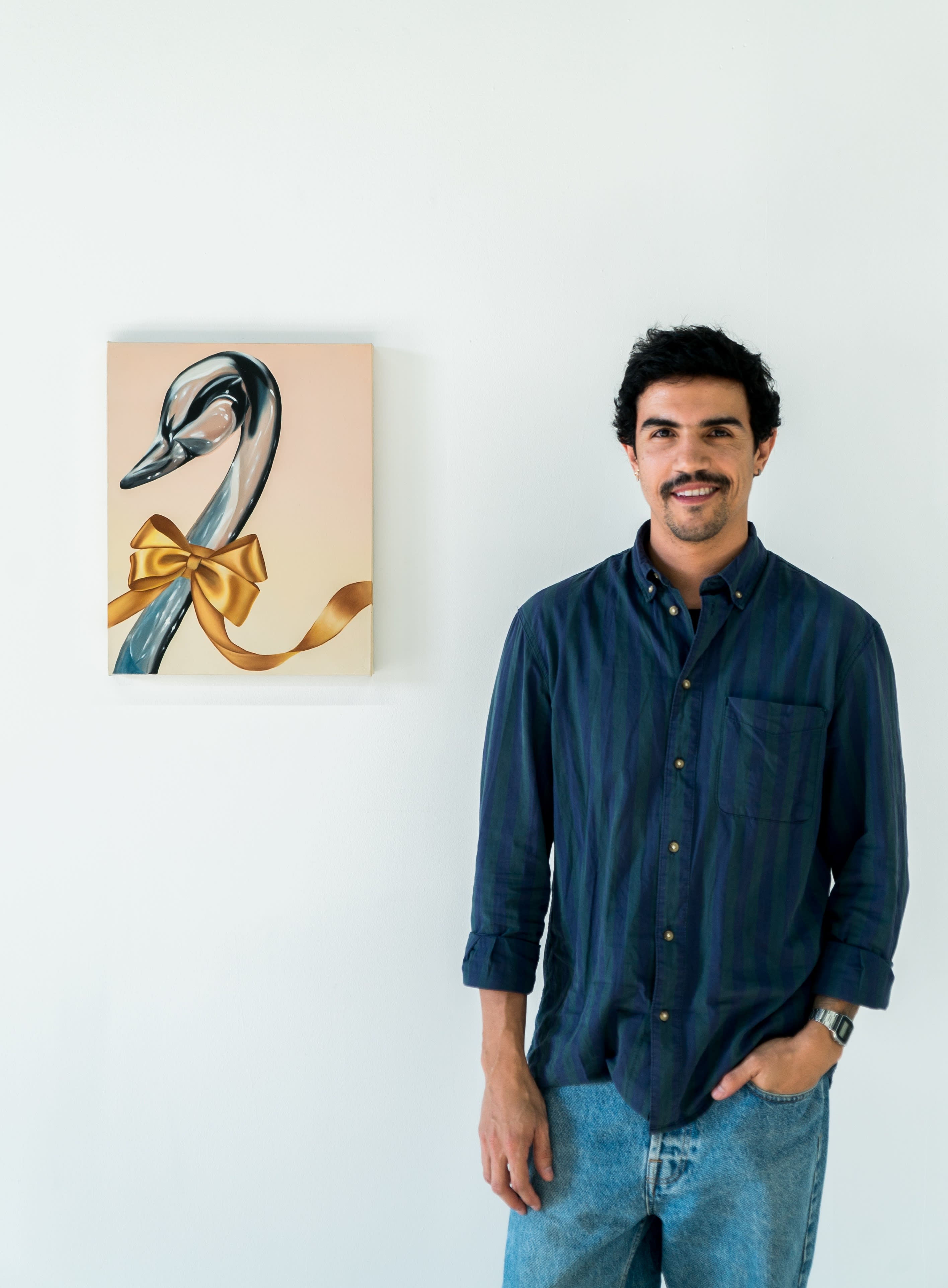 Photo of the artist Douglas de Souza next to one of his paintings