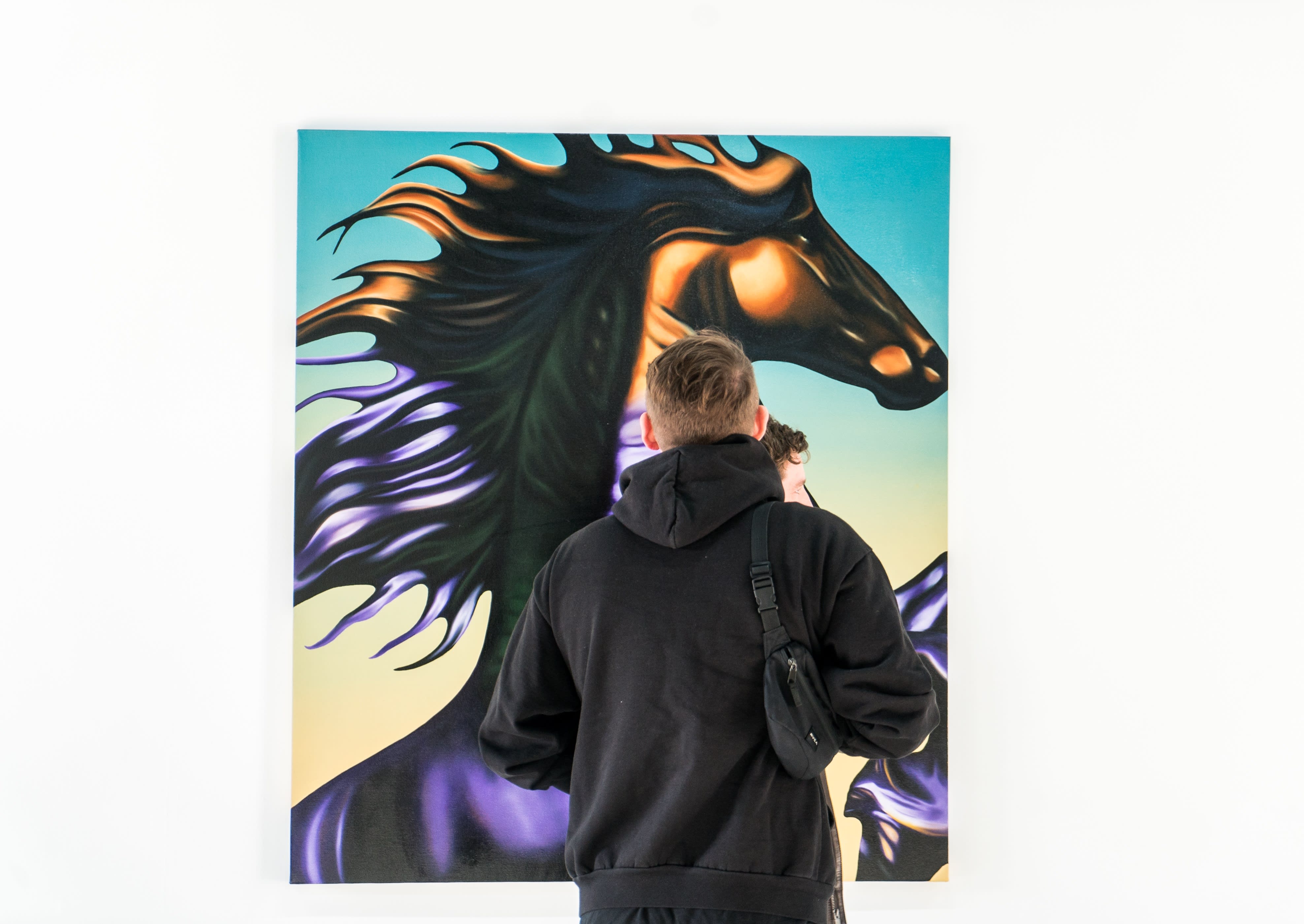 photo of a man standing in front of a painting
