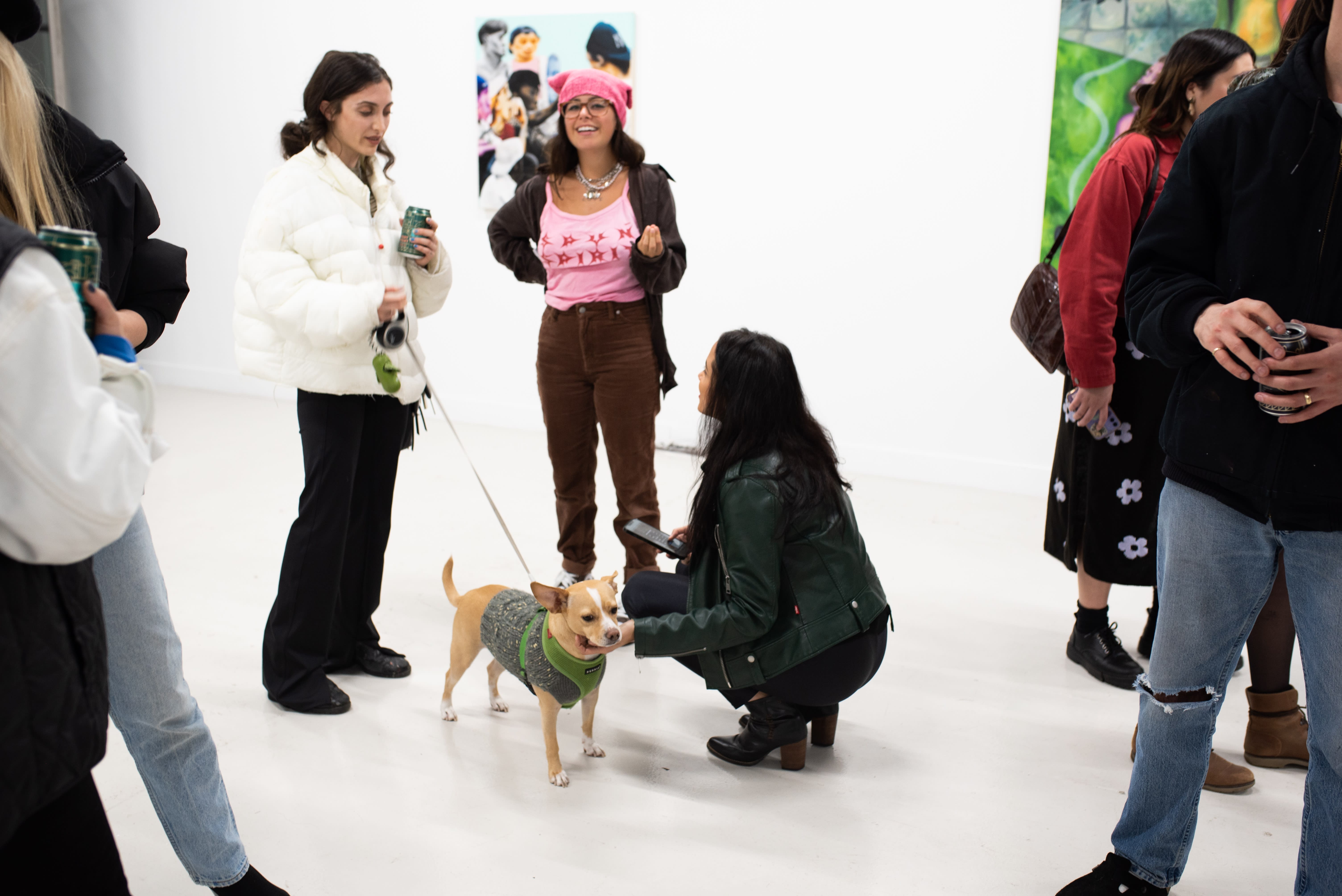 photograph of people inside the gallery surrounded by paintings and artwork