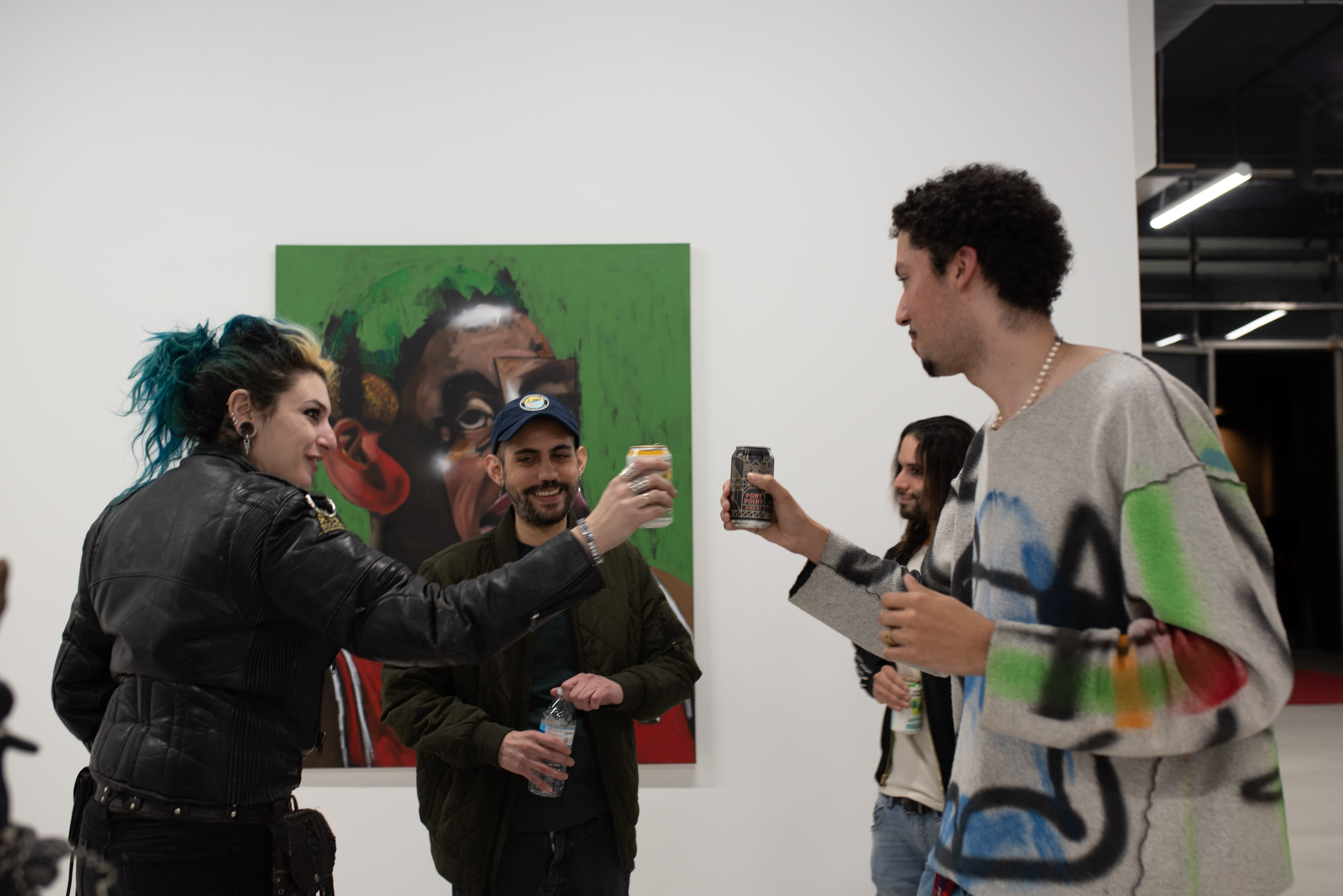 photograph of people inside the gallery surrounded by paintings and artwork