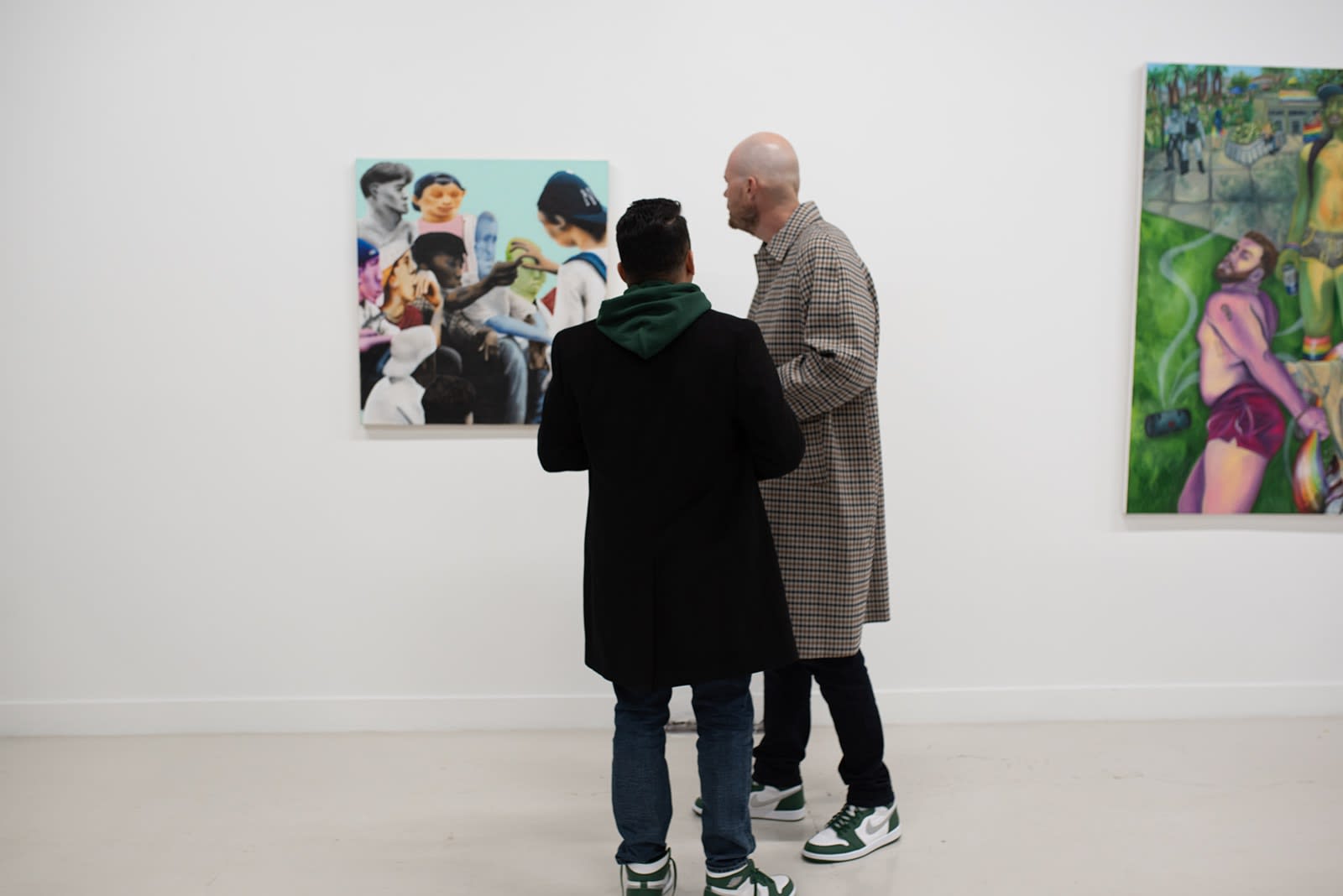 photograph of people inside the gallery surrounded by paintings and artwork