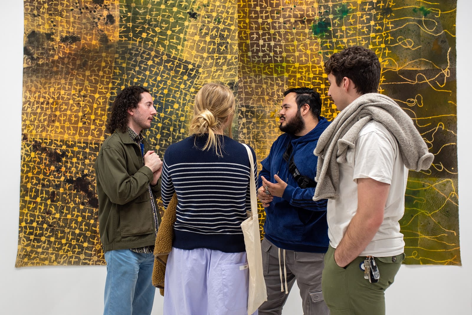 photograph of people inside the gallery surrounded by paintings and artwork