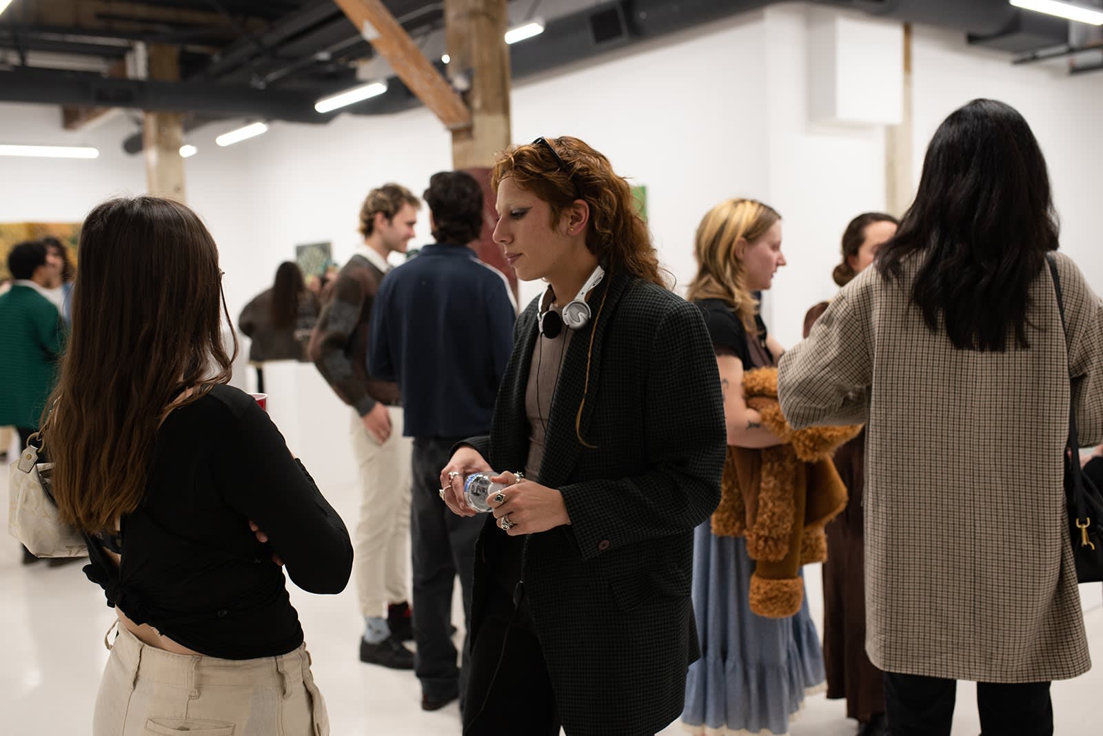 photograph of people inside the gallery surrounded by paintings and artwork