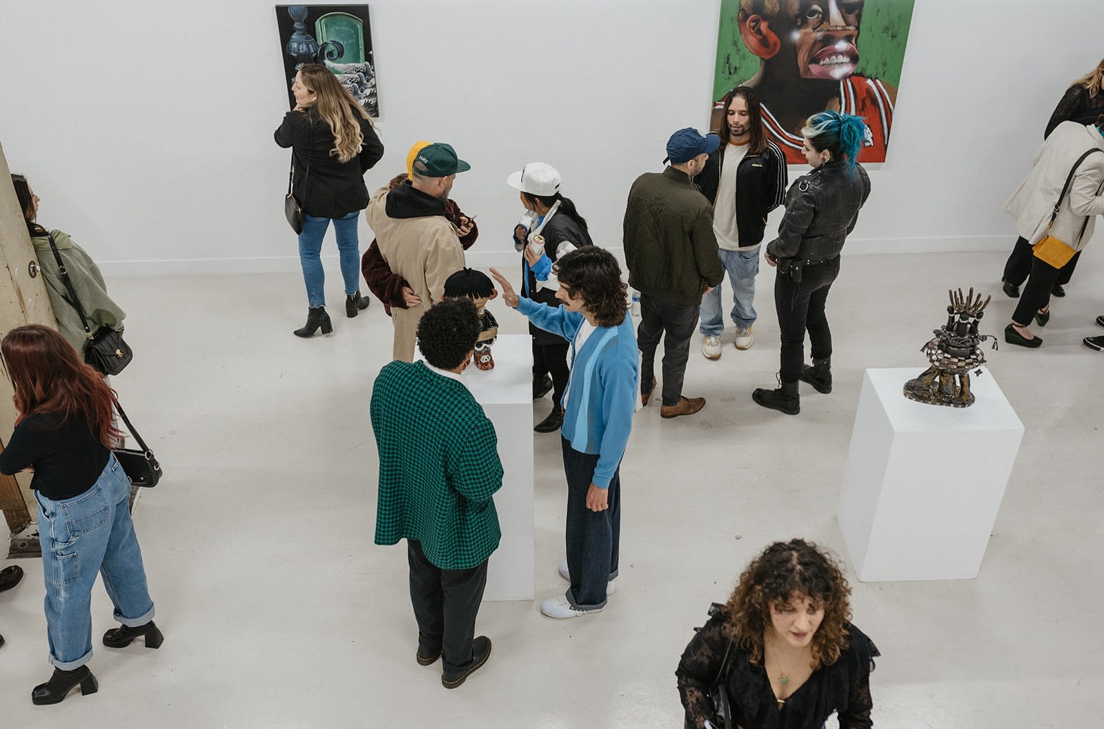 photograph of people inside the gallery surrounded by paintings and artwork