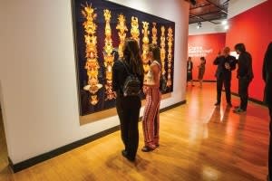 Paige Petersen and her roommate check out Amulet for Light I (Gold) as Carlos Betancourt chats with one of his constituents.