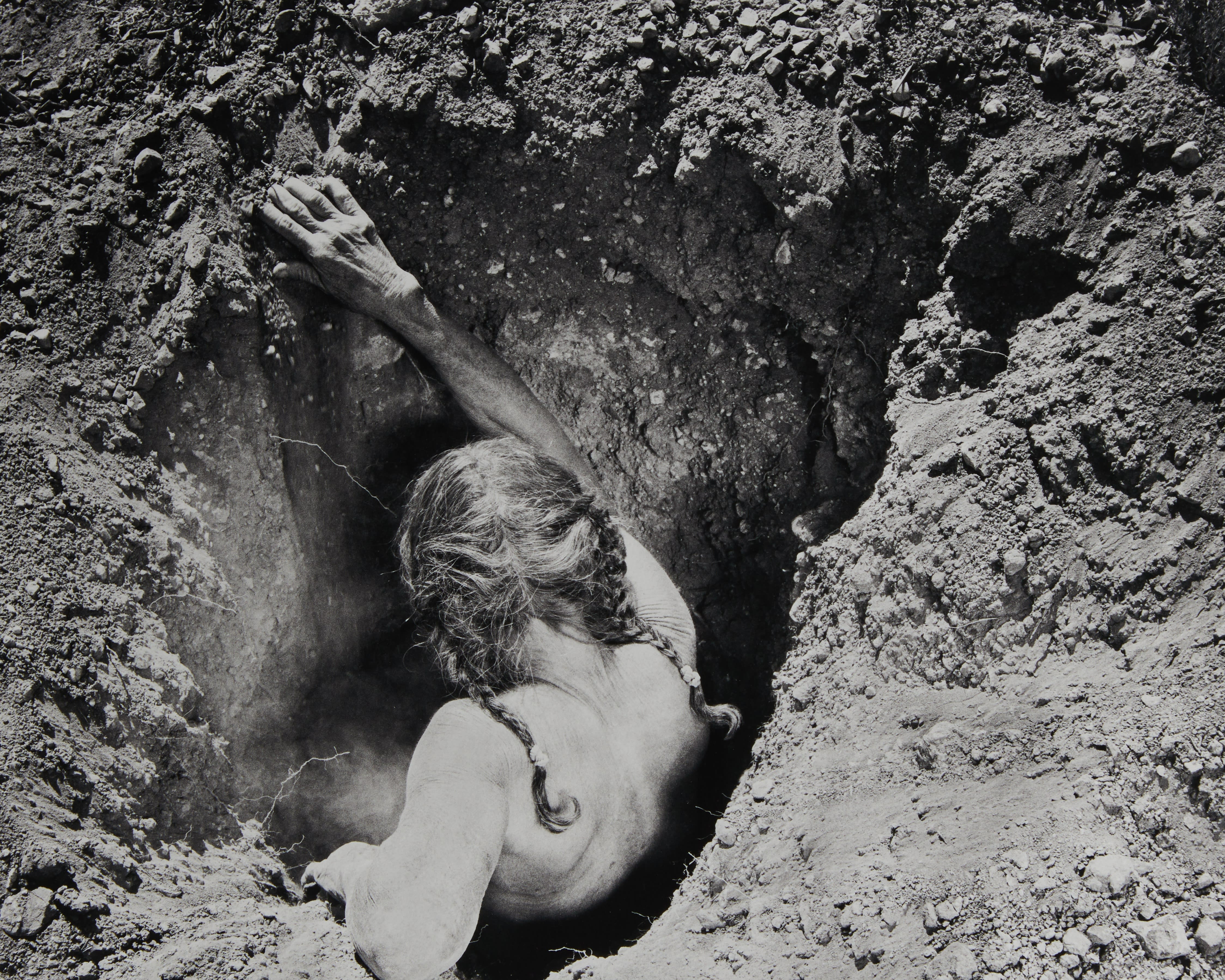 Woman crawling into hole