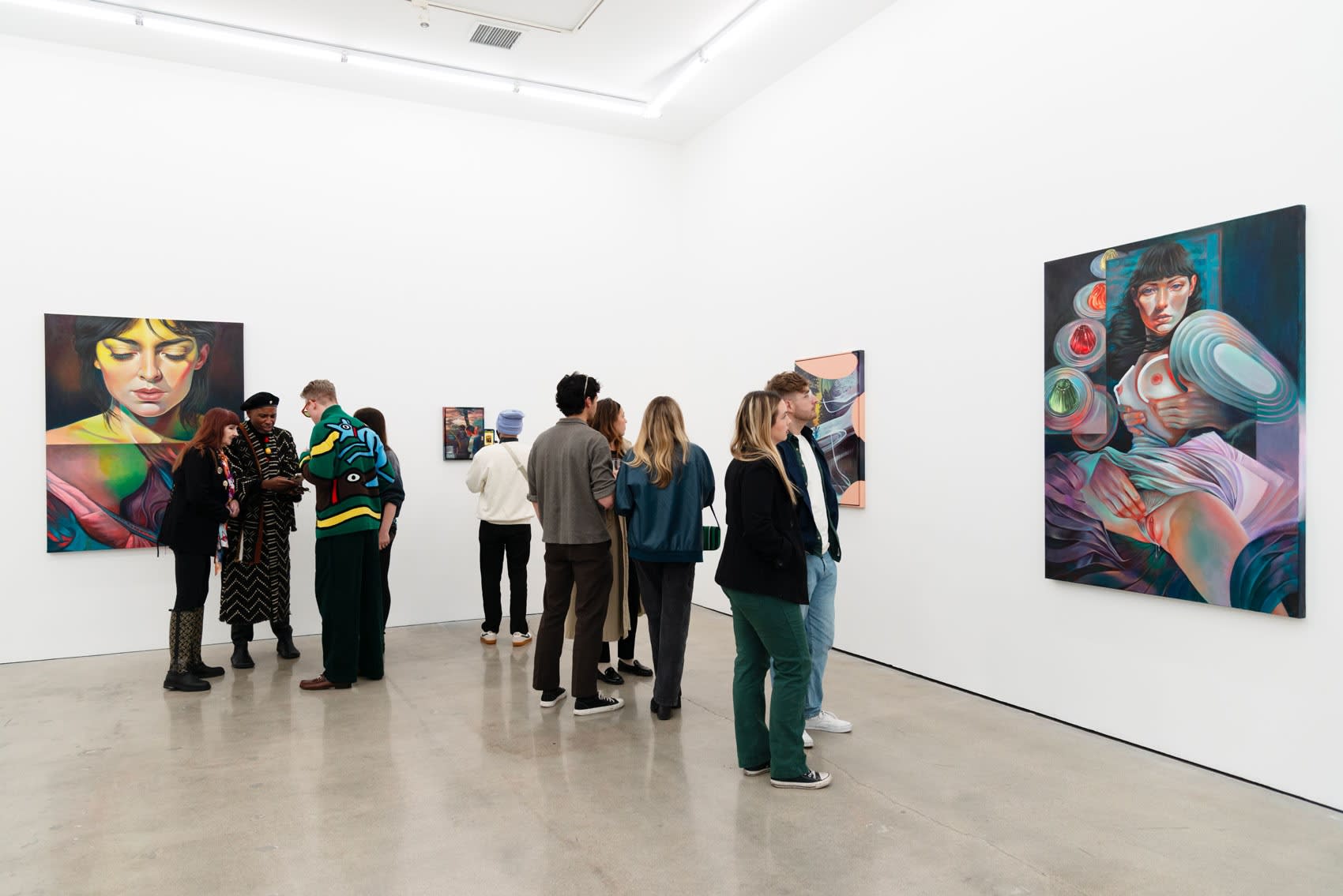 Image of a group of peopel talking at an art gallery with white walls and a concrete floor at the opening of Martine Johanna's solo exhibition 