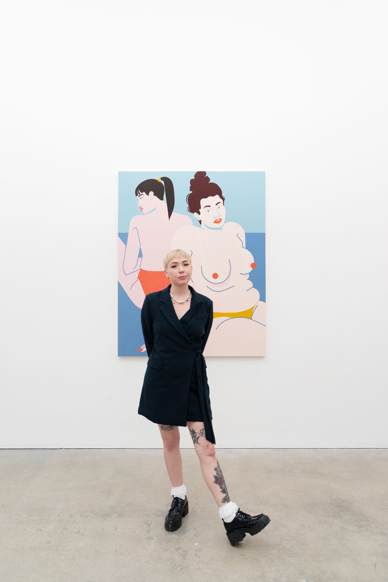 Artist Jillian Evelyn in front of her painting 