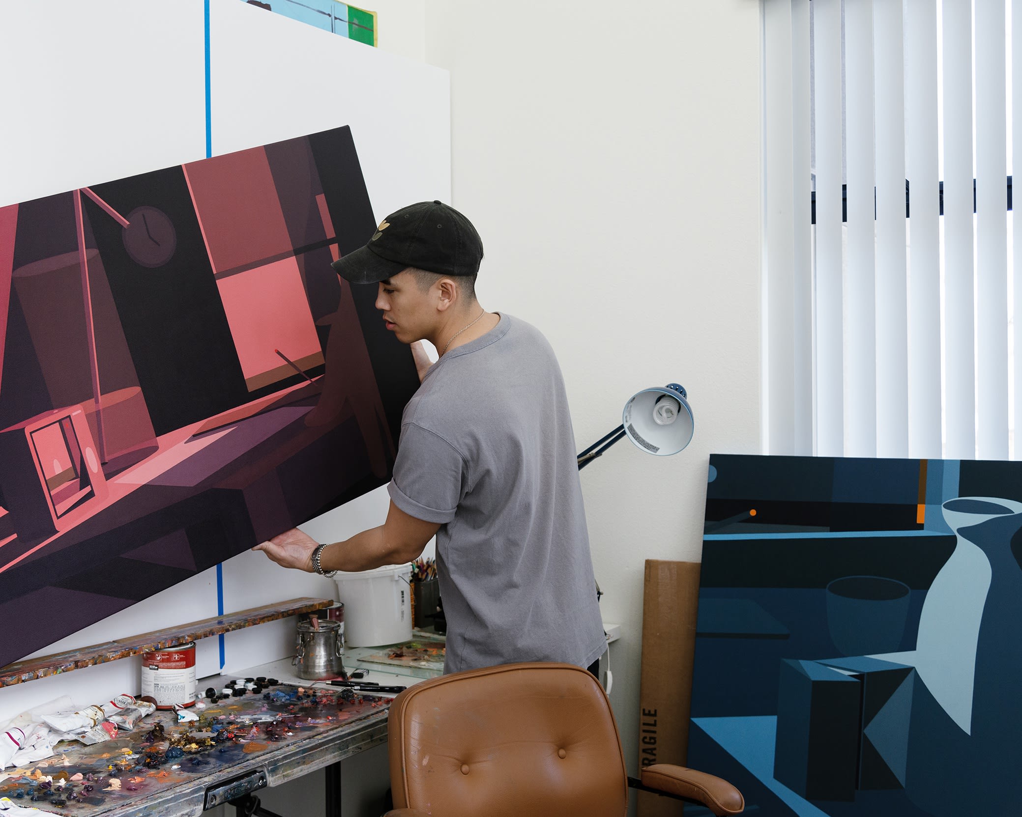 Adrian Kay Wong in his studio with his paintings for Softly