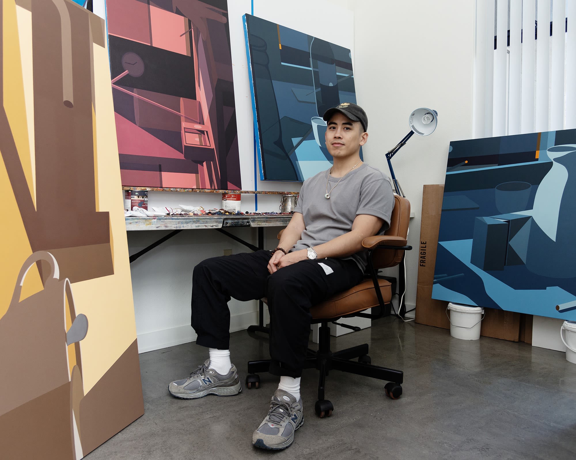 Adrian Kay Wong in his study with his paintings for Softly