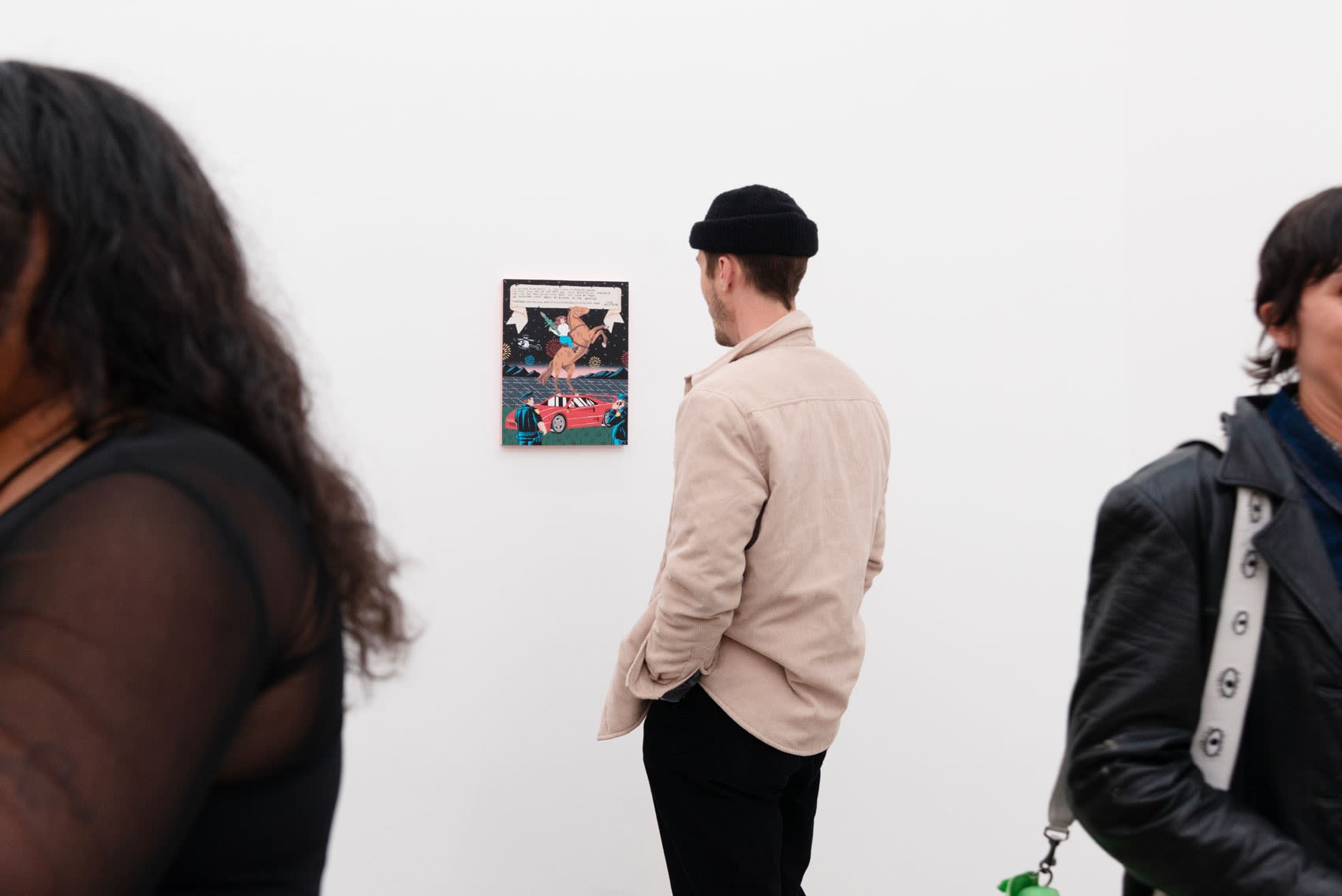 A man looking at a painting on the wall