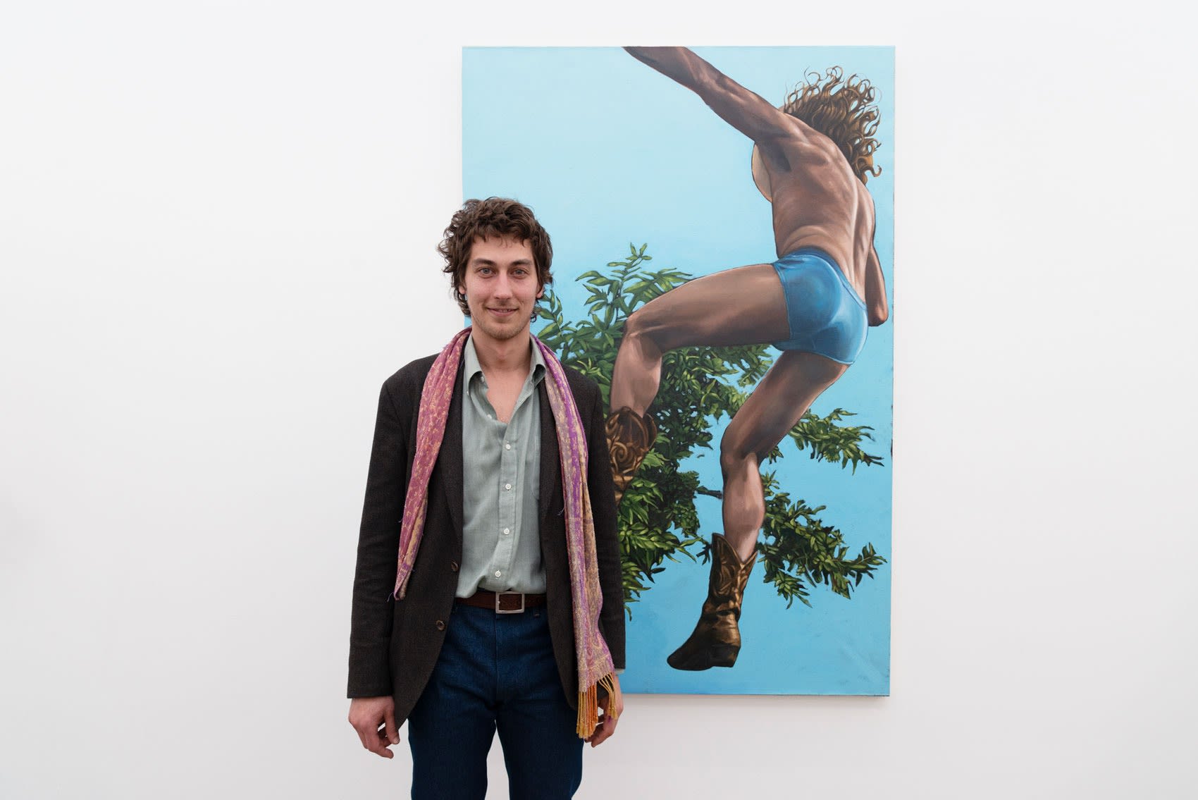 Artist Dylan Roworth in front of his painting