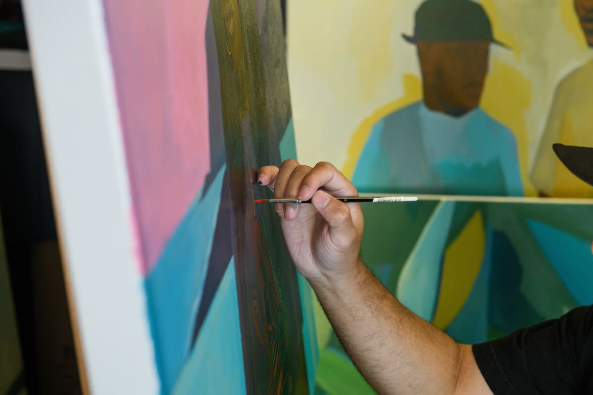 Photo of Dennis Brown painting in his studio