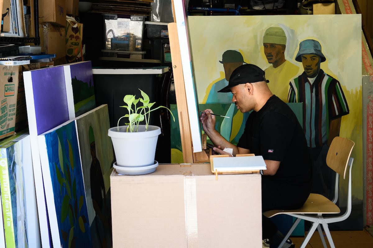 Photo of Dennis Brown painting in his studio