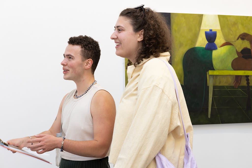 two people looking at the painting at a hilda palafox exhibition