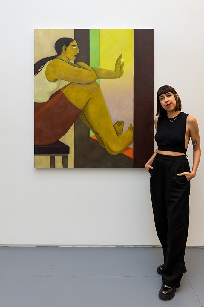 portrait of art Hilda Palafox standing with one of her paintings