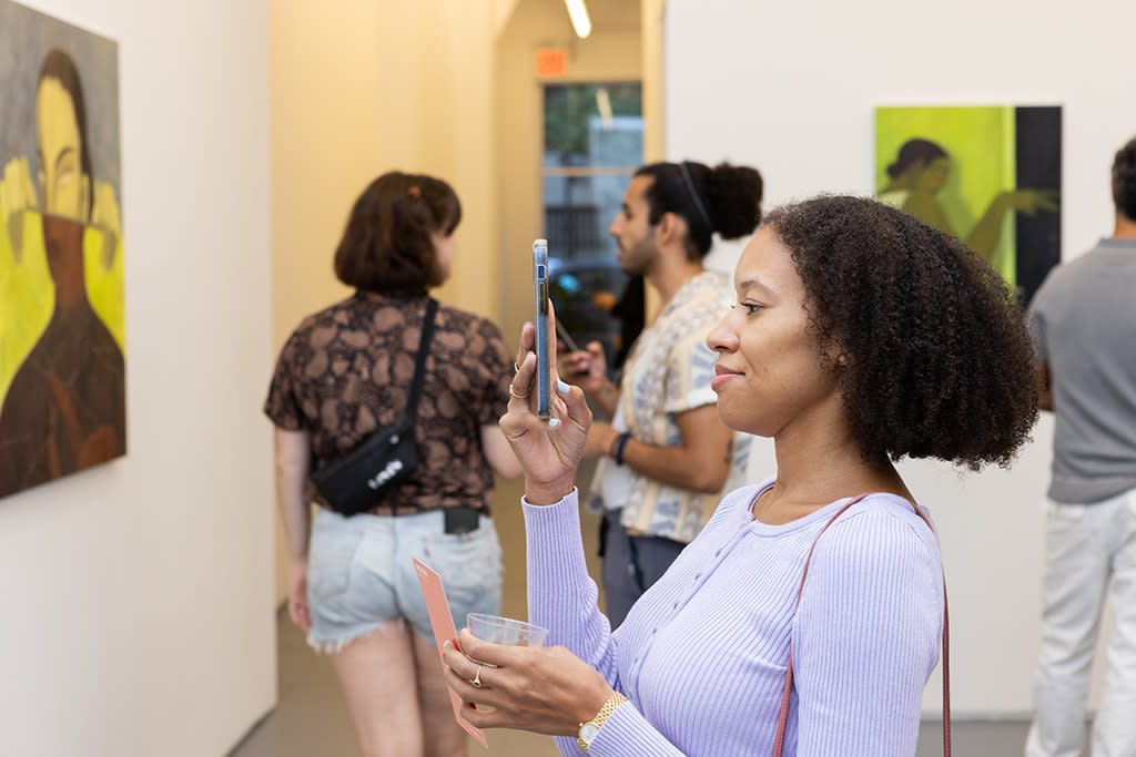 woman taking a photo at opening night reception