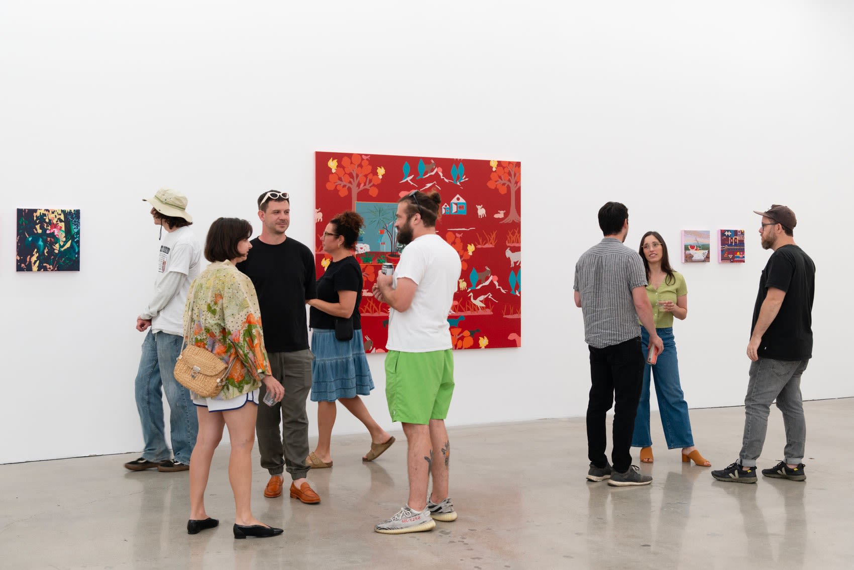 Francisco Díaz Scotto speaks to attendees in front of his bright red painting.