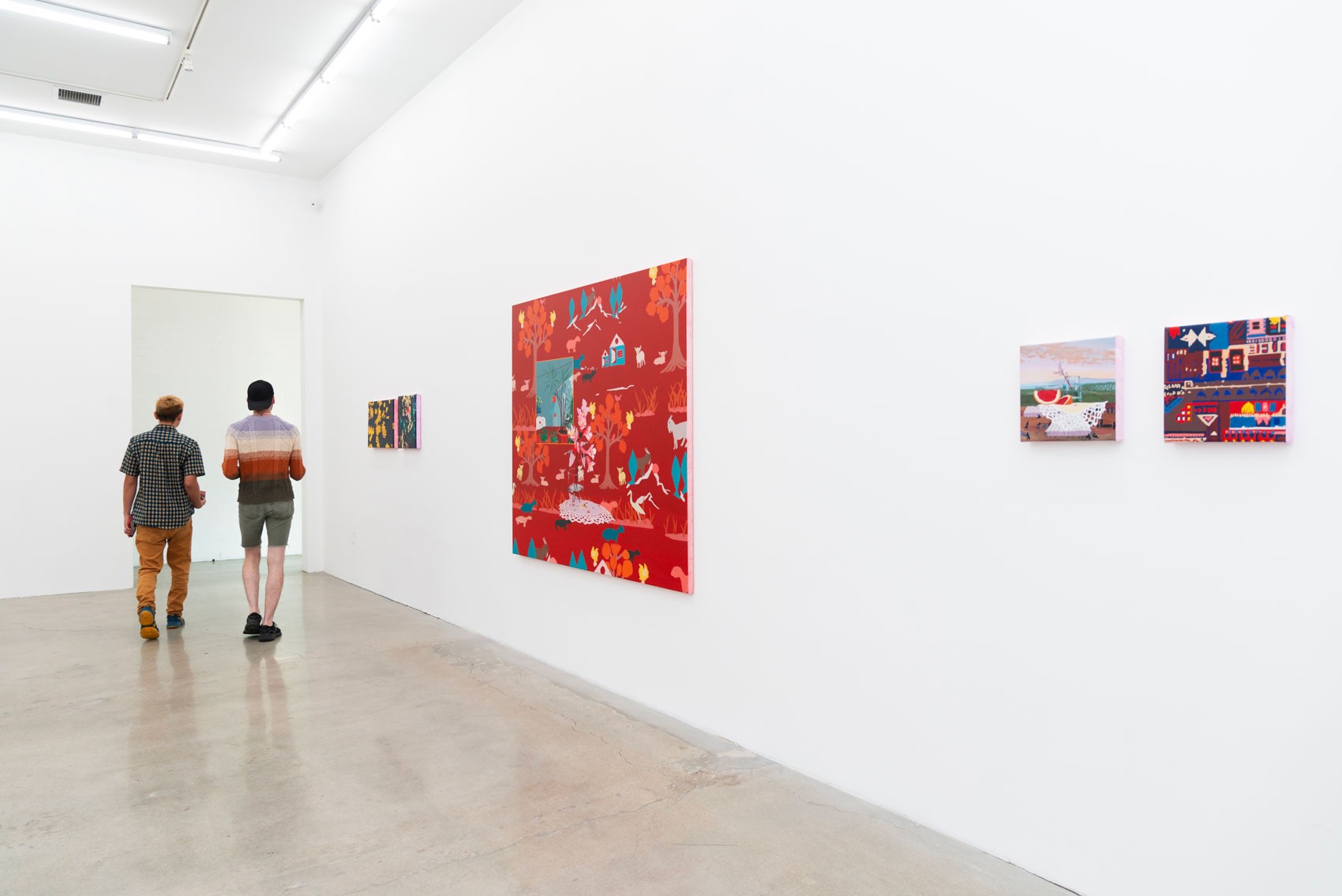 attendees at the opening of Where Dreams Touch Ground, a solo show by Francisco Díaz Scotto. A red painting hangs on a white wall in a cavernous room with concrete floors.