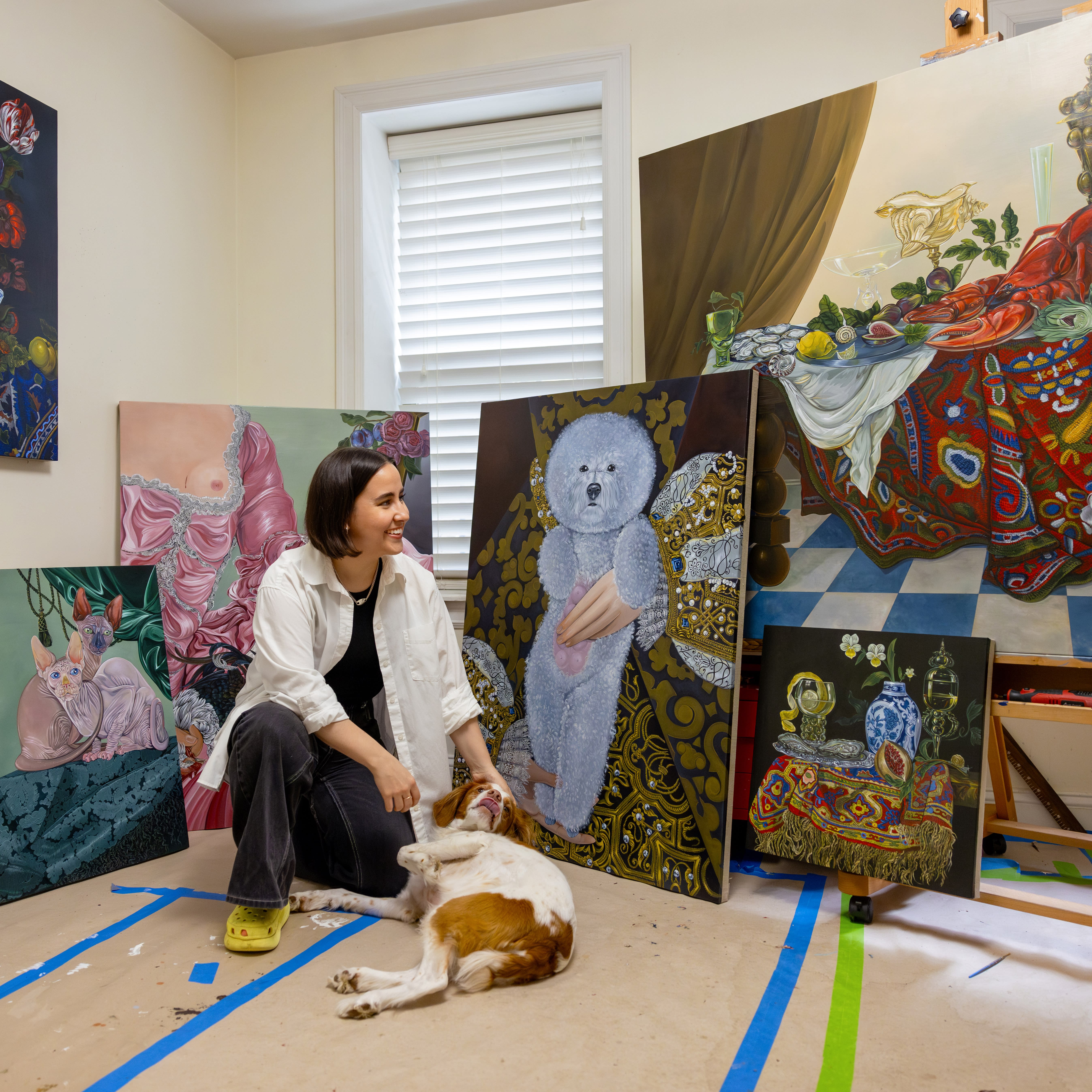 Artist Sabrina Bockler with paintings and dog