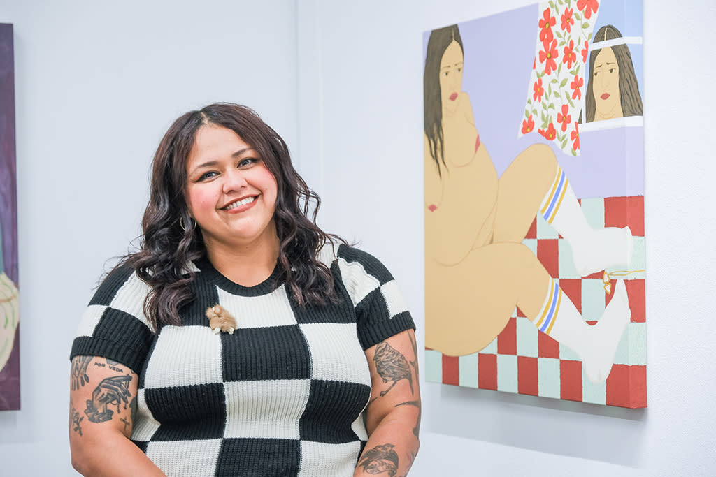 Photo of artist Gina M. Contreras next to her work at the opening reception of 