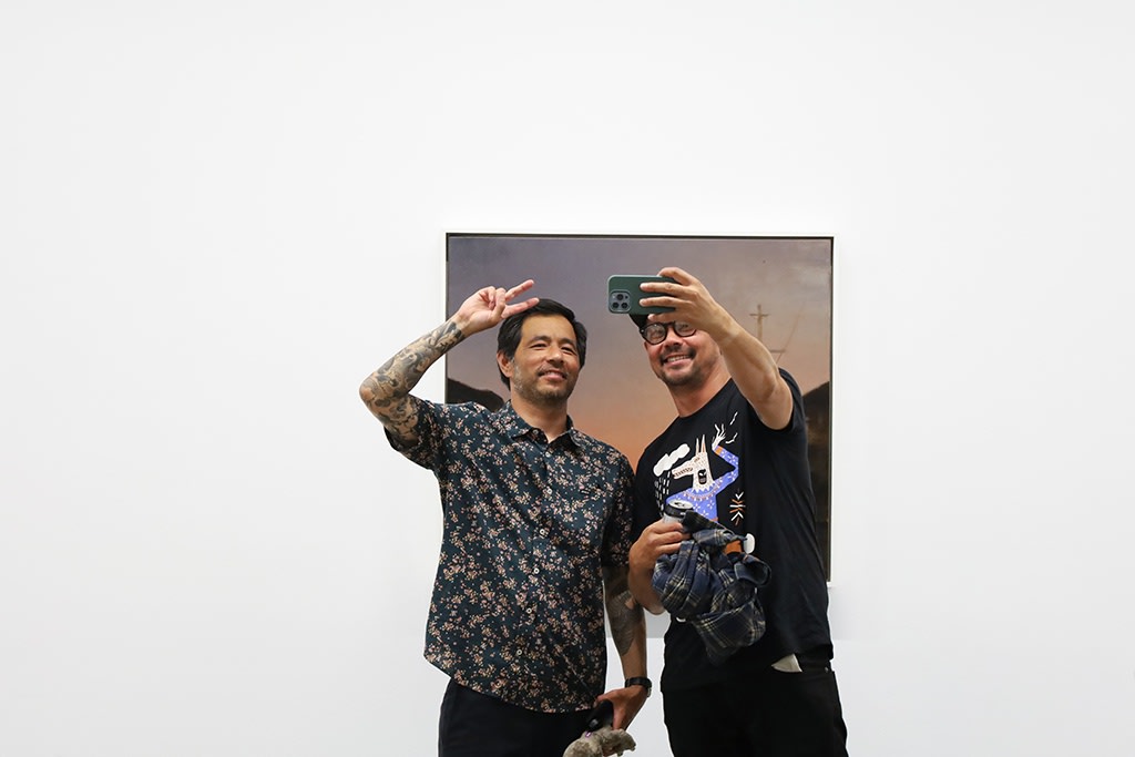 Kim Cogan and guest taking selfie in front of painting