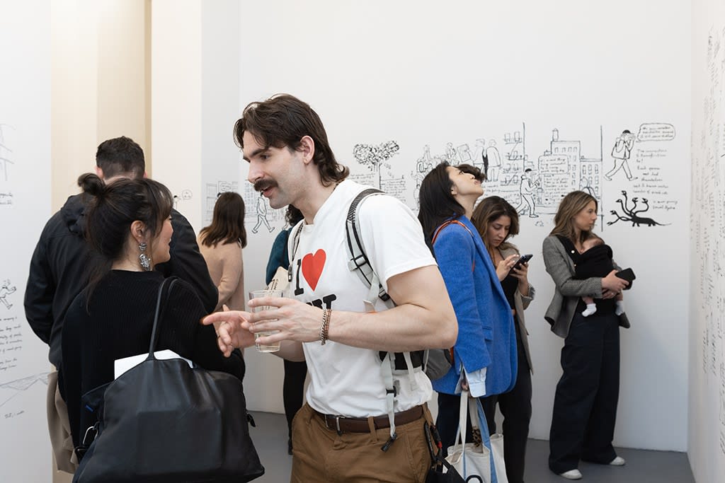 Visitors at Jean Jullien's solo exhibition LOLO mingle and look at the art. 