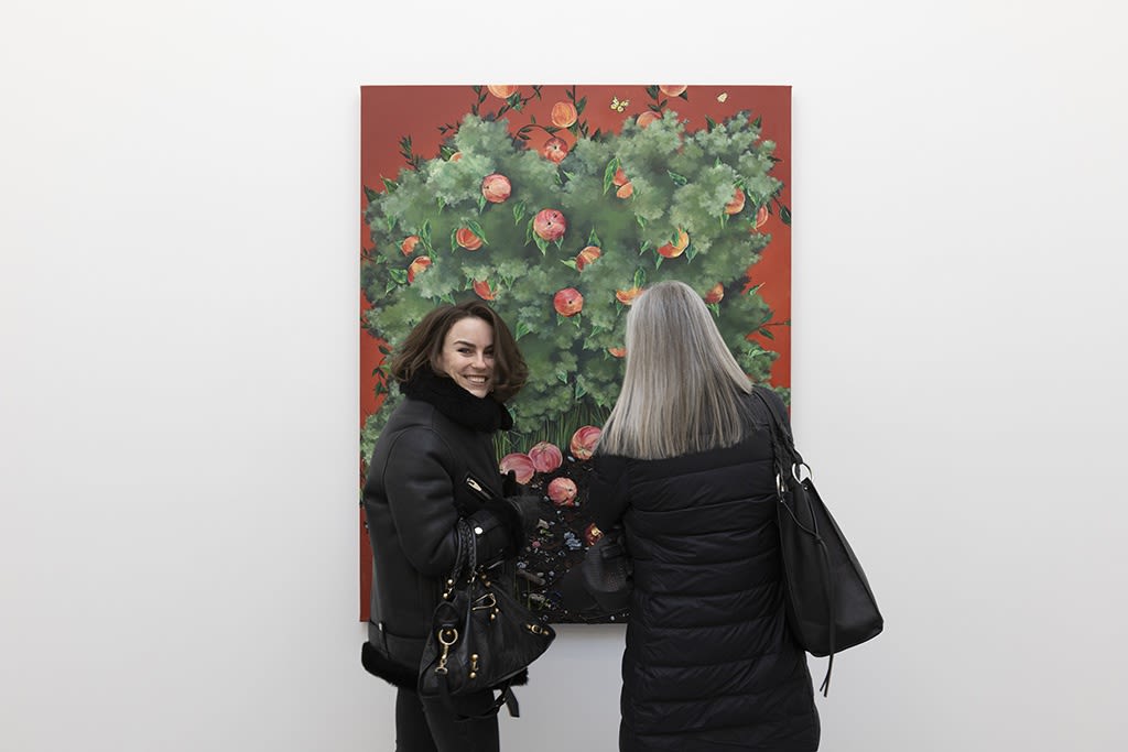 two people standing in front of a painting