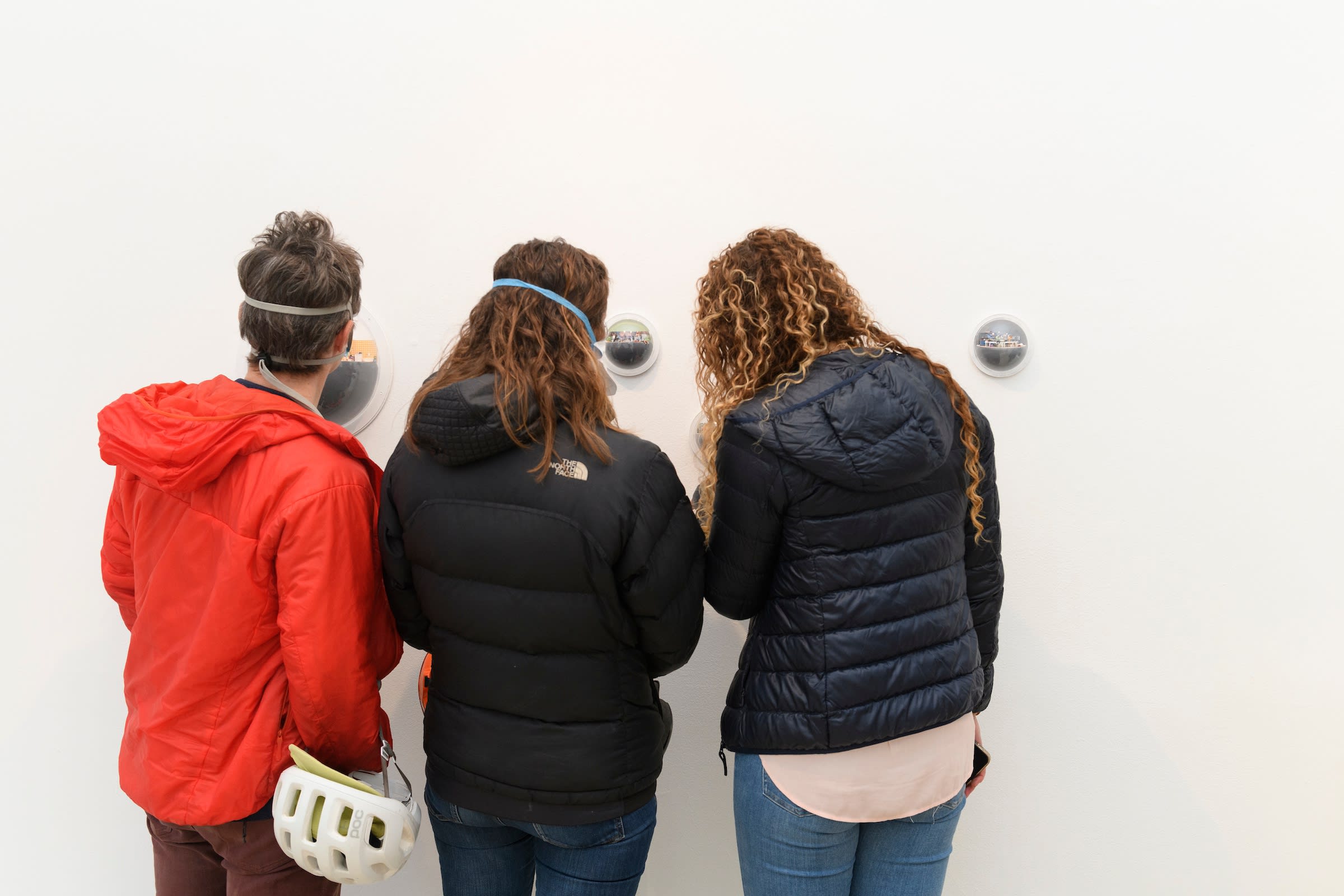 three people admiring Abigail Goldman's work at her show opening 