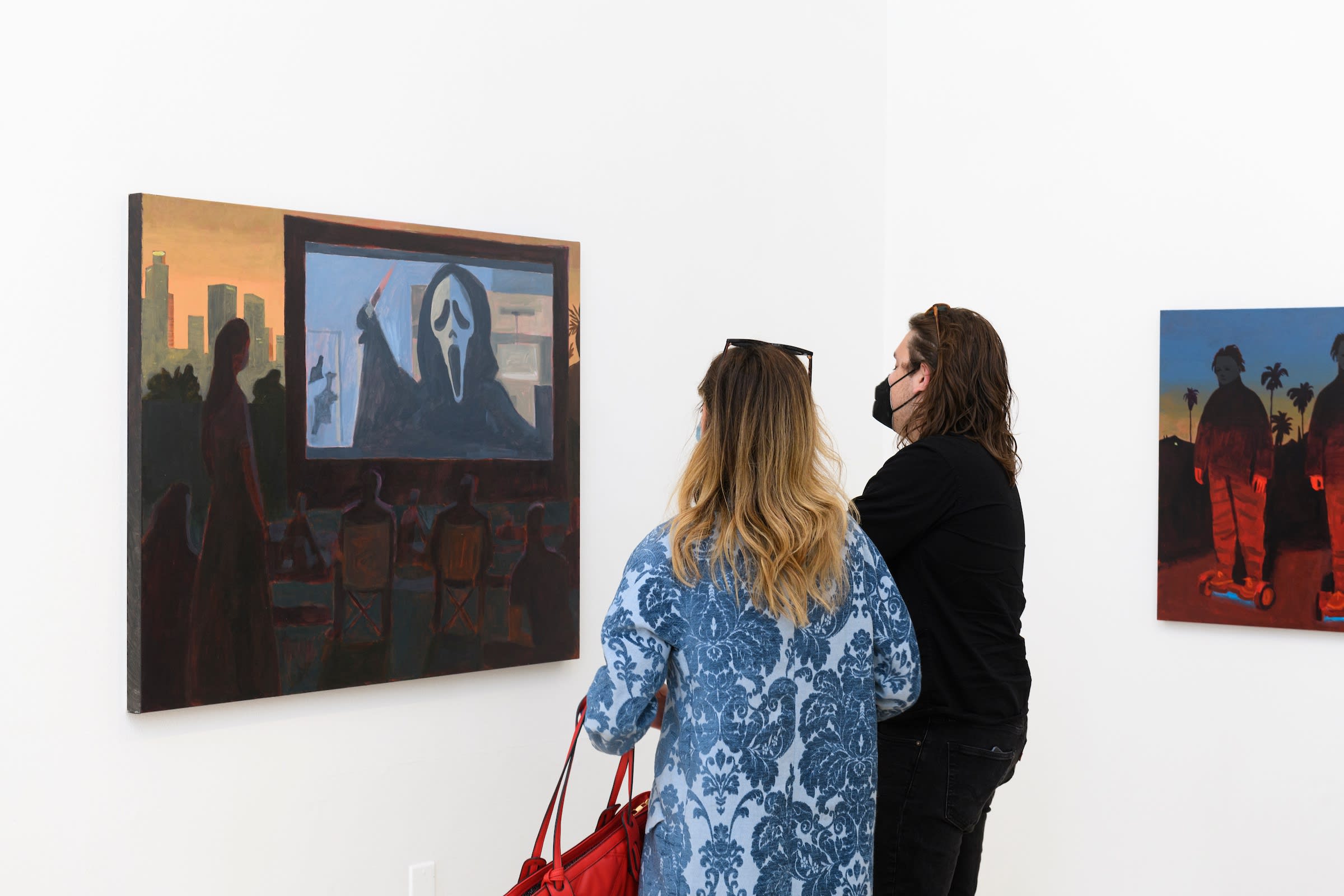 two people looking at Woodrow Whites painting of a drive in 