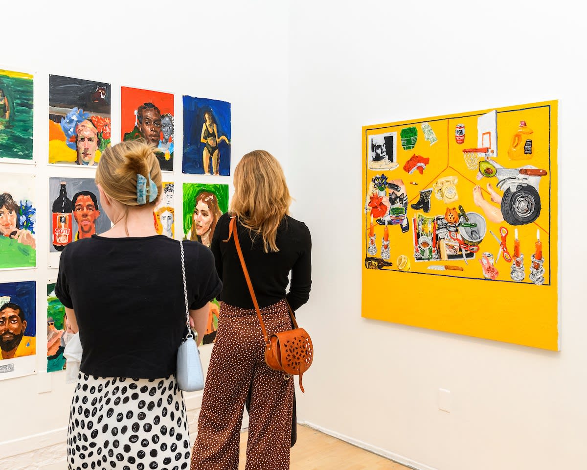 Opening reception photo of people looking at artwork