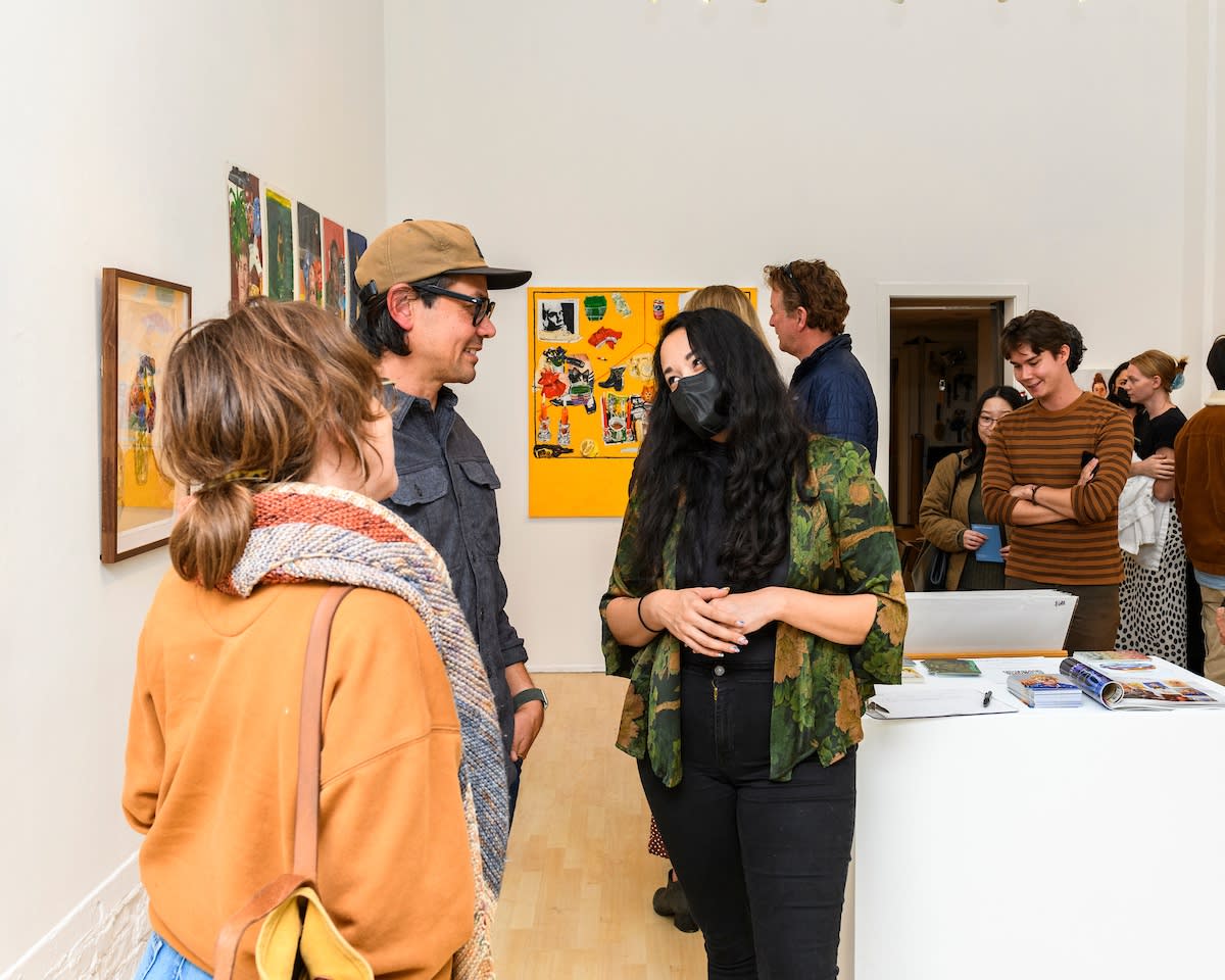 Opening reception photo of people viewing the art 