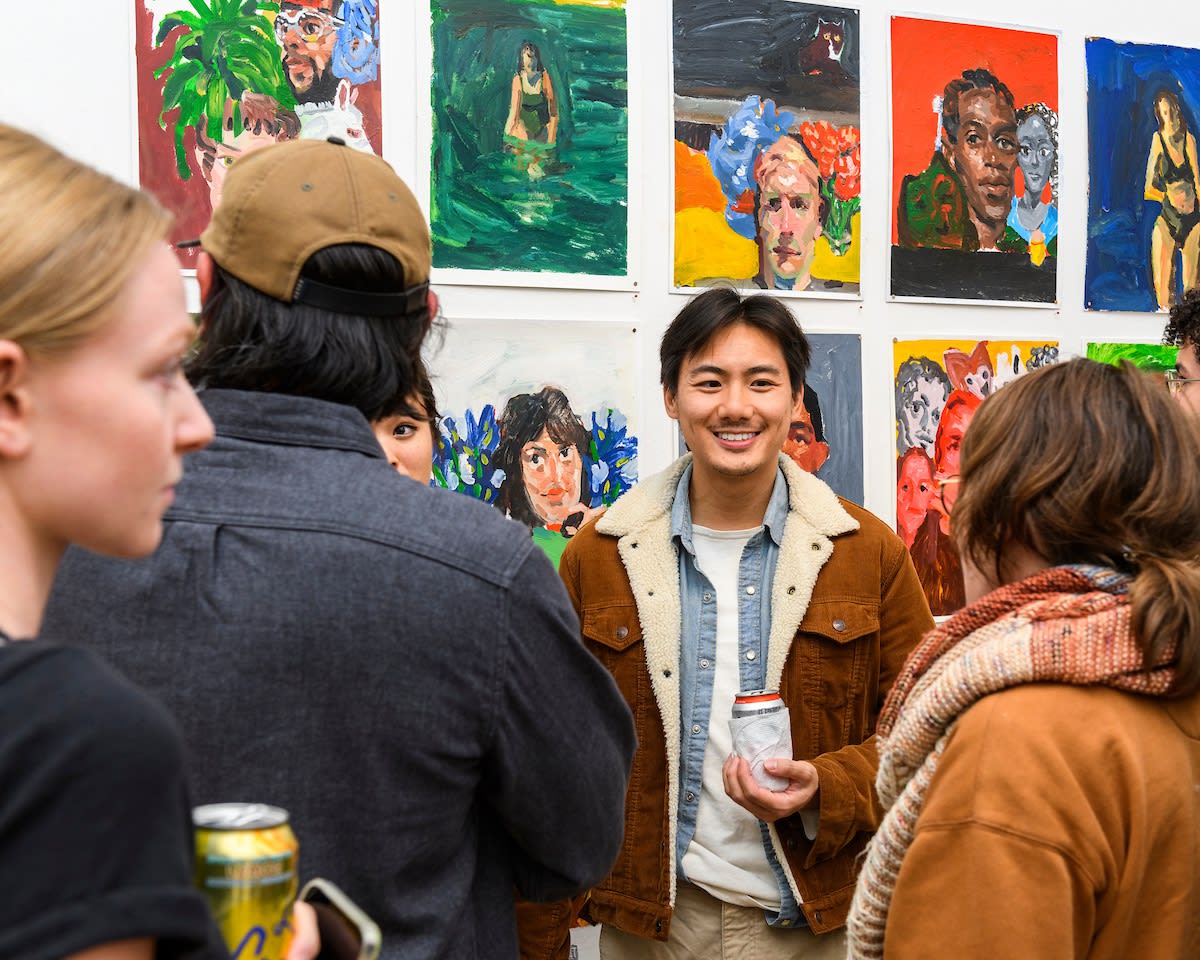 Opening reception photo of people looking at artwork