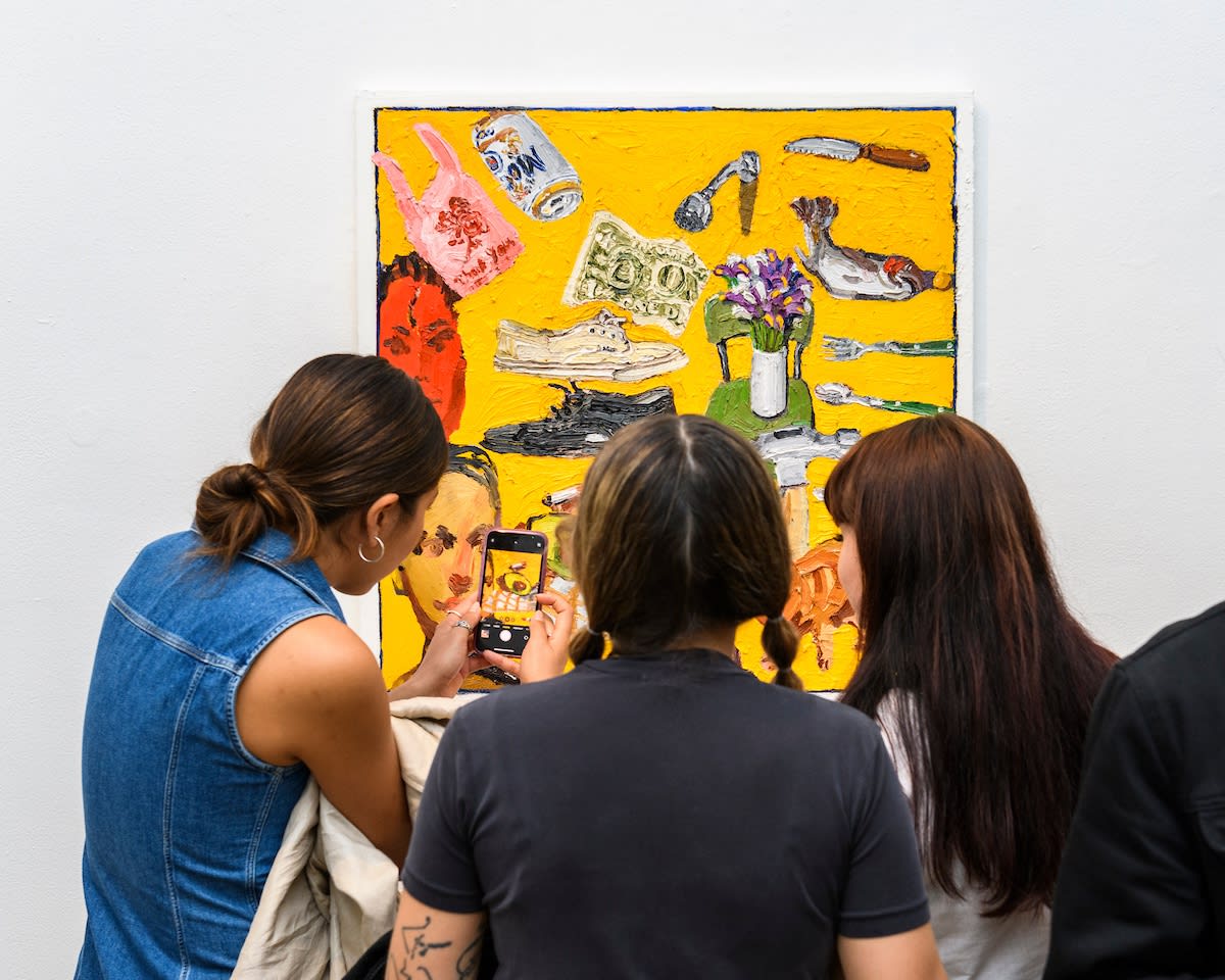 Opening reception photo of people looking at the artwork