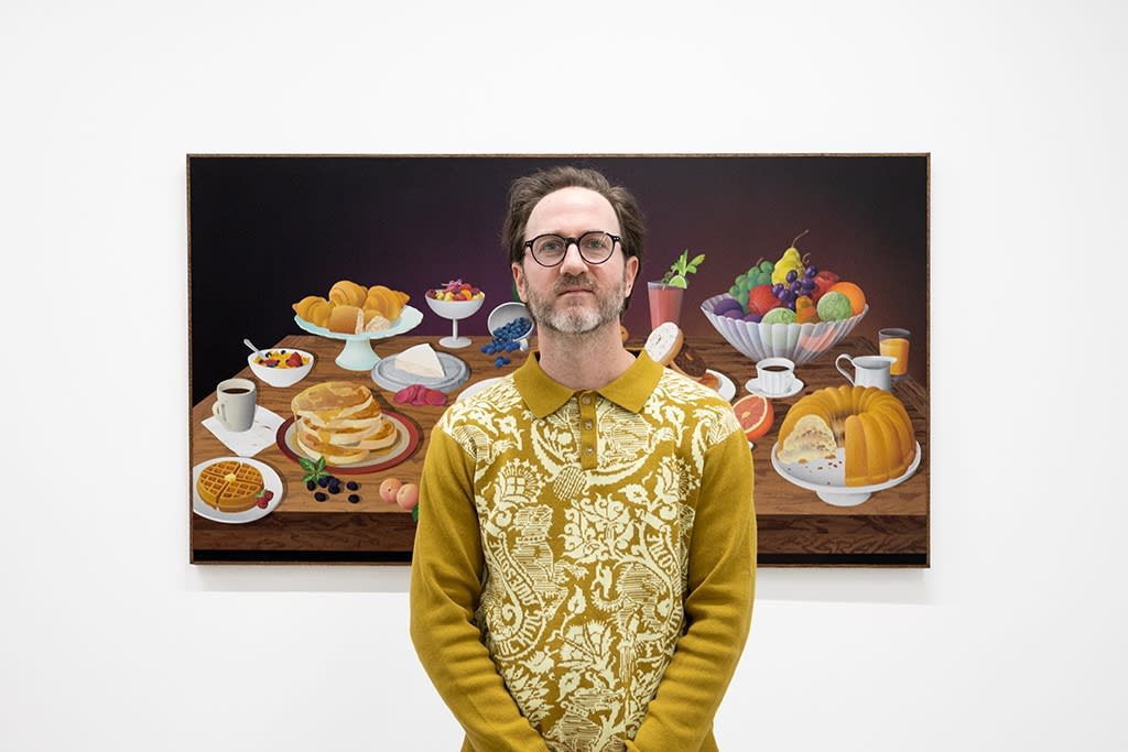 Casey Gray stands in front of his painting at the opening of his exhibition 