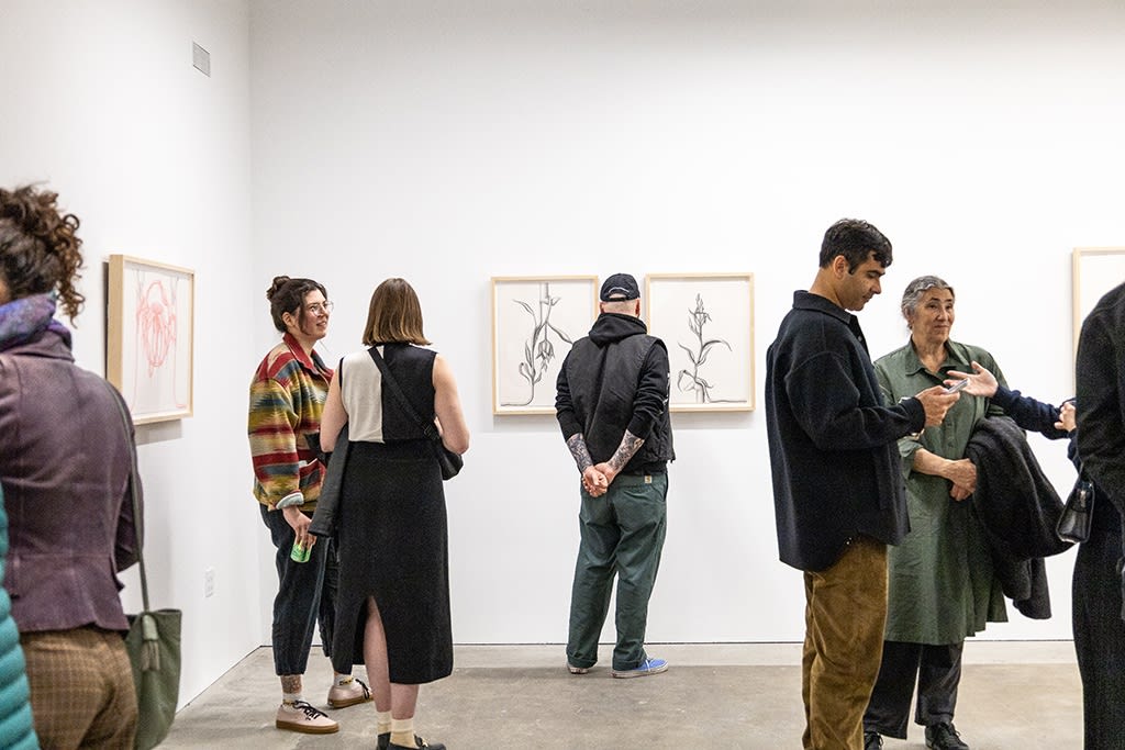 People mingle at the openign reception of Devra Fox's solo exhibition In Orbit. 