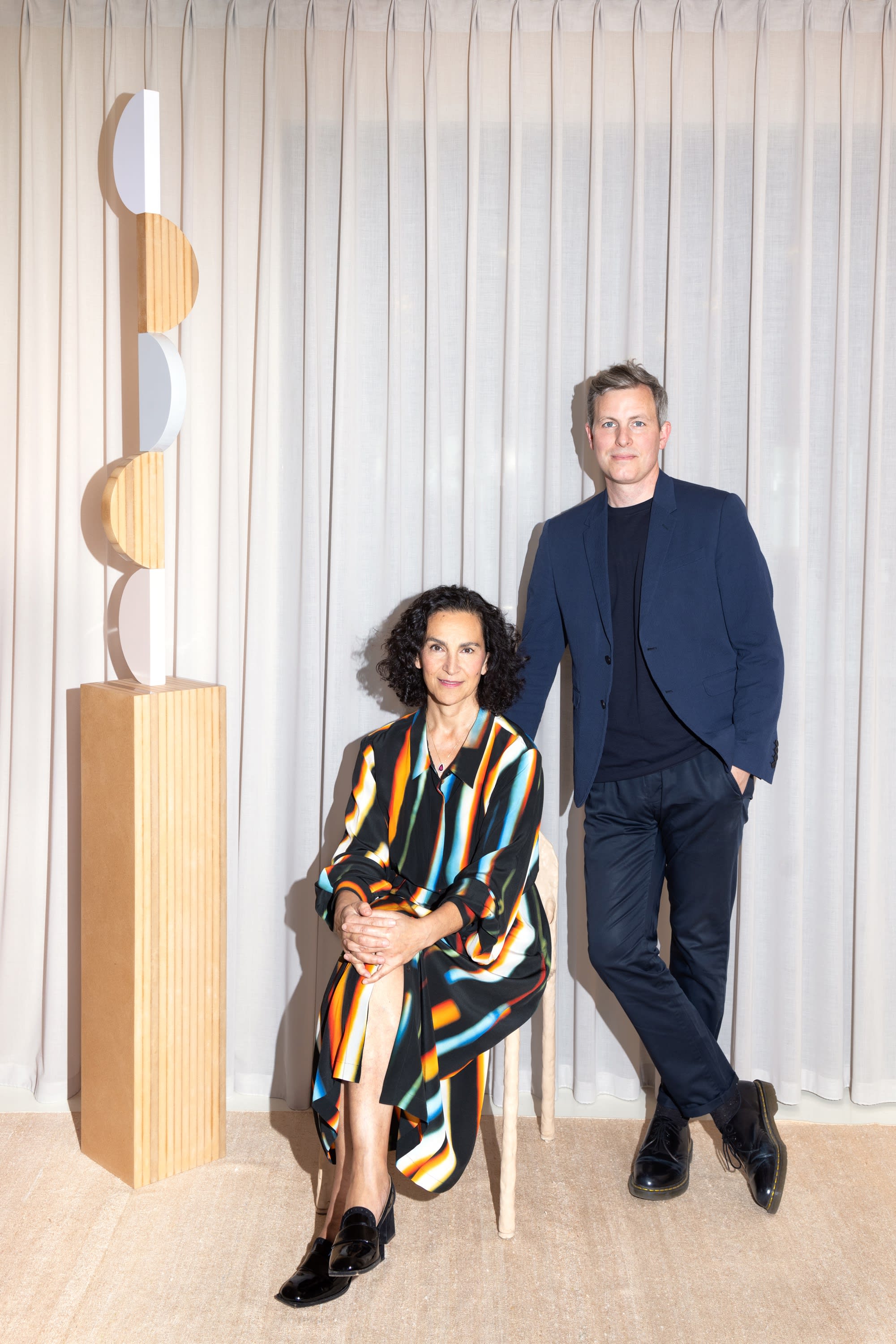 Shula Nazarian and Seth Curcio beside a totemic sculpture by Reuven Israel