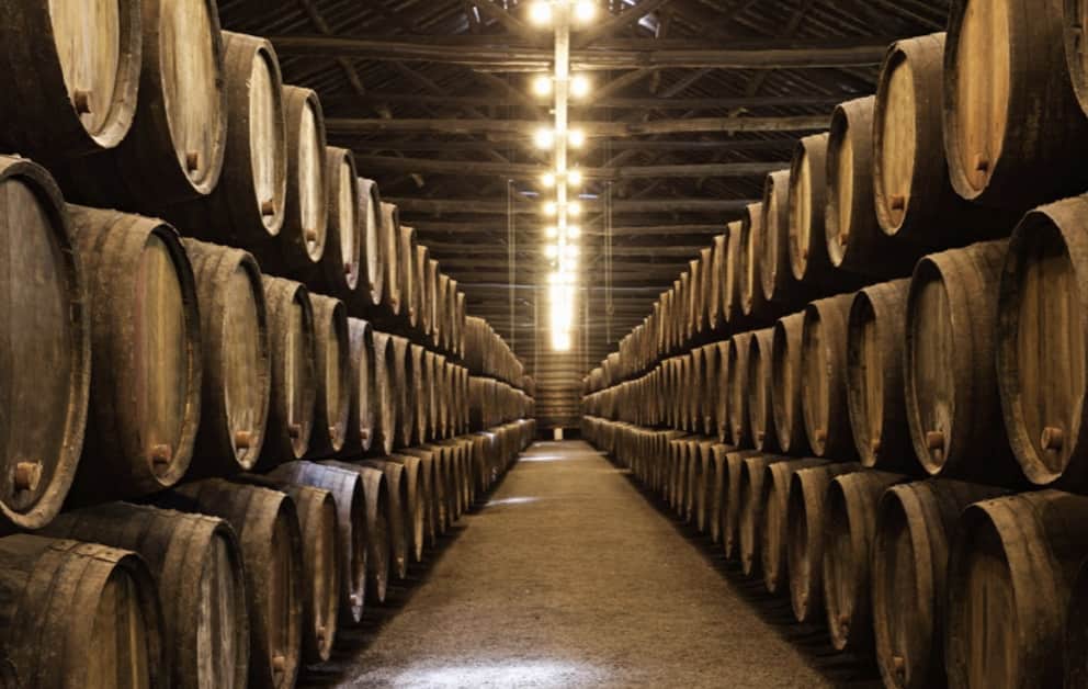 If you invest in whiskey casks, you need to wait years to see how much they will appreciate, like these barrels of rare whiskey investments stacked in a cellar.