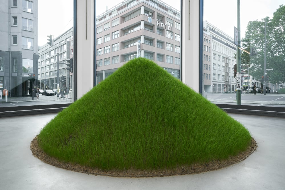 The Artwork by Hans Haacke "Grass Grows", a small hill with natural grass, exhibited in the corner space of Galerie Thomas Schulte