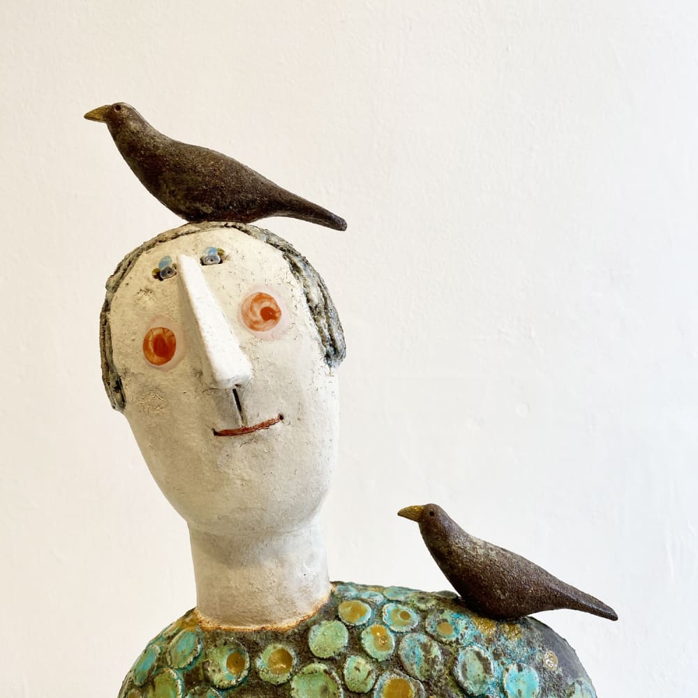 Jane Muir figurative ceramic sculpture with birds perched on the head and shoulder