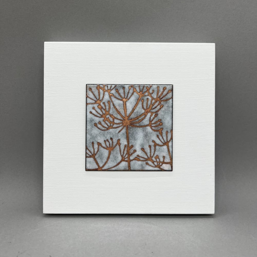 Janine Partington Vitreous enamel on capper plate on wooden panel with a seed pod design