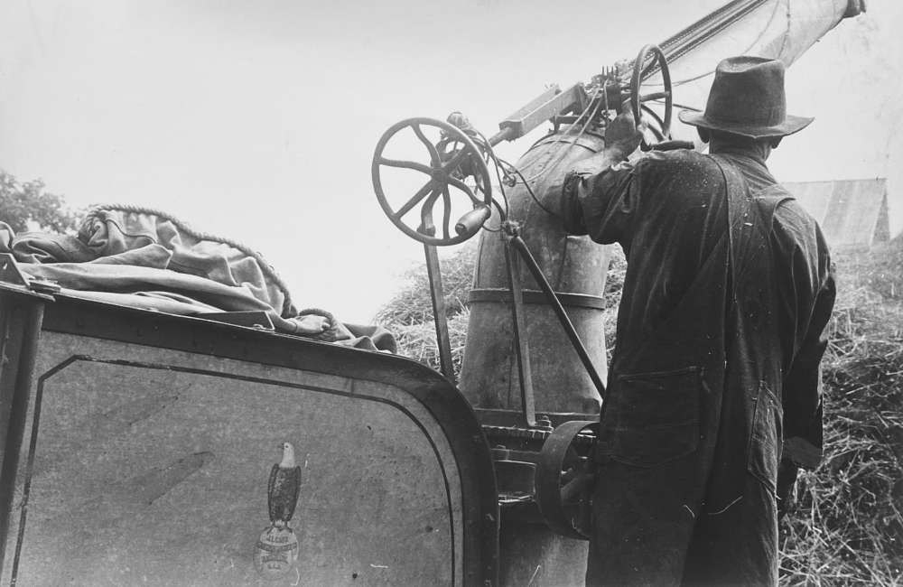 Ben Shahn, Adjusting straw stocker on grain separator, central Ohio, 1938