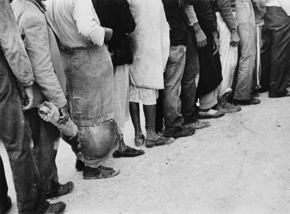 Marion Post Wolcott, Migrant vegetable pickers waiting in line to be paid, behind truck in field near Belle Glade, Fla., 1939