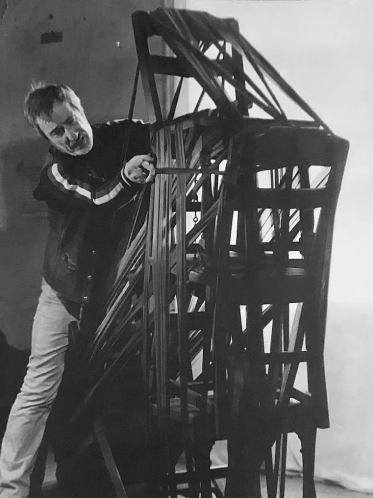 Francis Hines wrapping stacked wooden chairs in 1978.