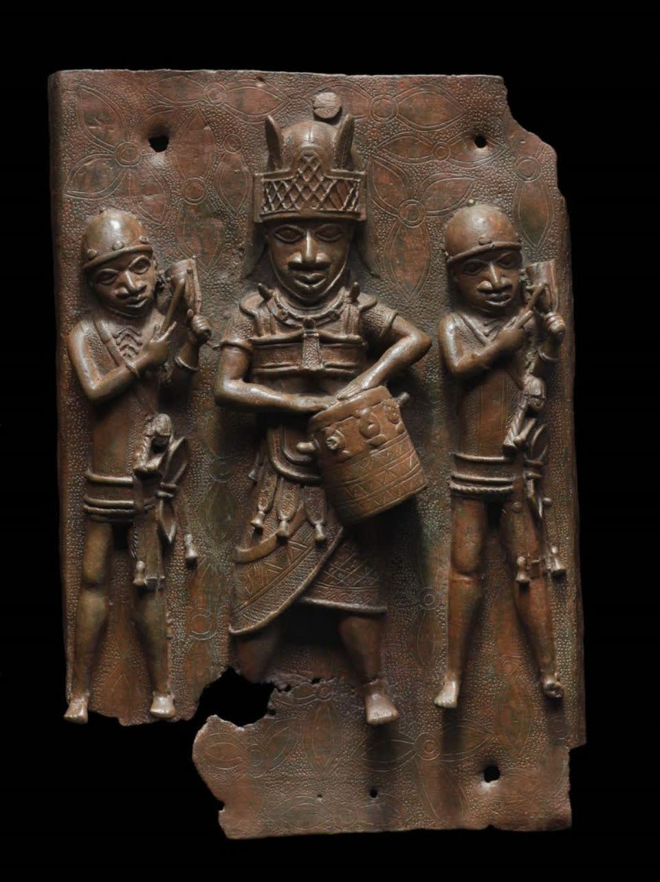 Relief plaque showing a dignitary with drum and two attendants striking gongs. Edo peoples, Benin kingdom, Nigeria, 16th–17th century. 43.2 x 27.9 cm. Courtesy Museum of Fine Arts, Boston (#L-G 7.32.2012).