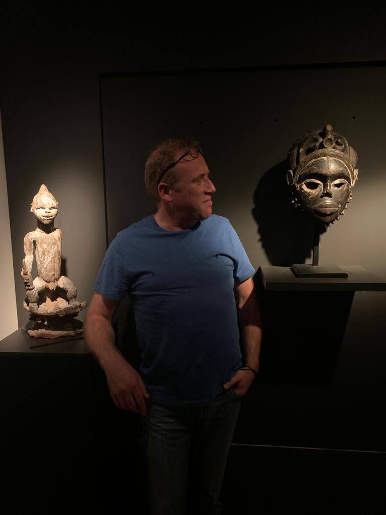Jan de Clerck at his home with an Igala statue and Ibibio mask, December 2022