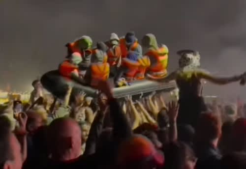 image of an inflatable dinghy with mannequins dressed up as immigrants crossing the channel, part of an intervention by Banksy at the Glastonbury Festival